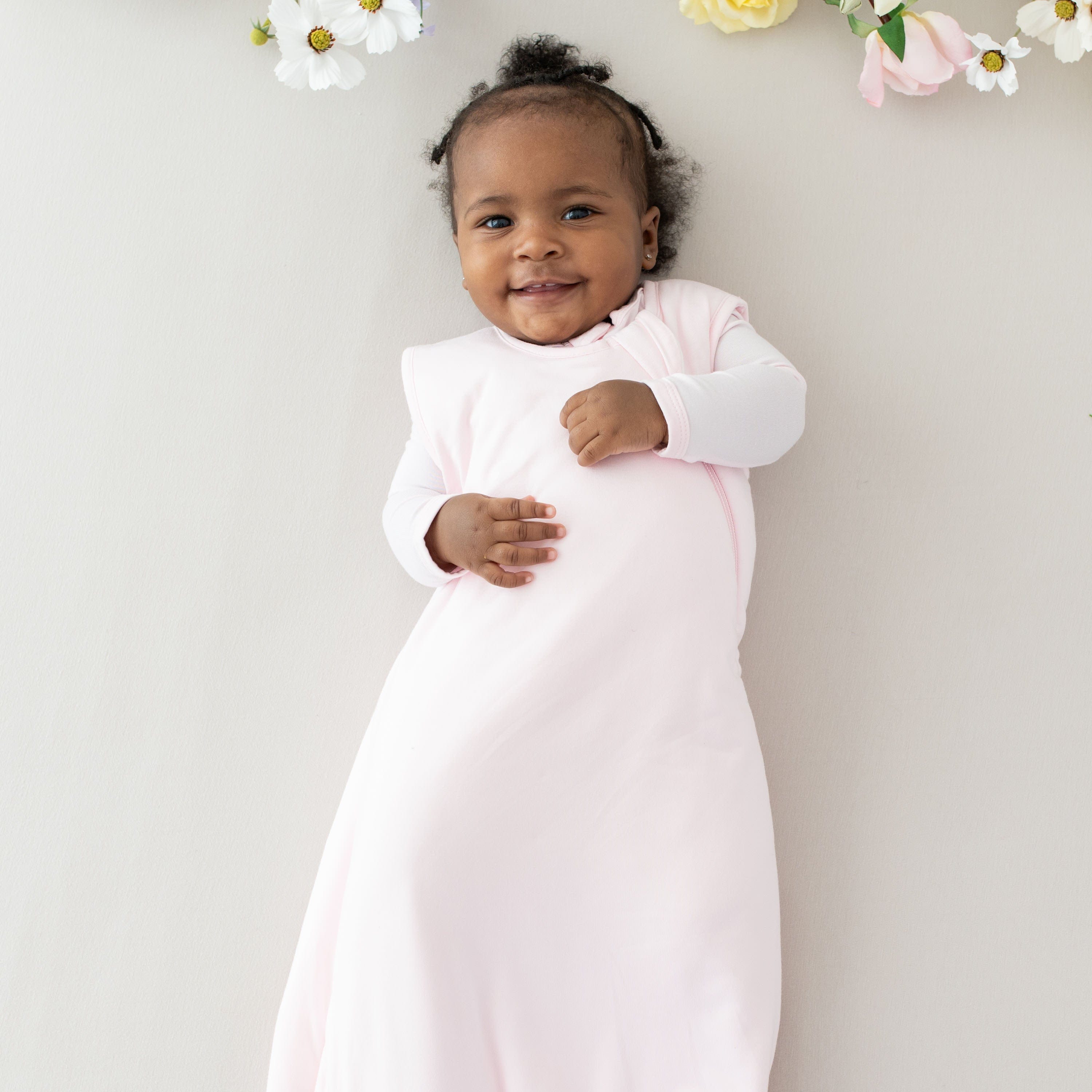 Infant wearing Kyte Baby Sleep Bag in Sakura 1.0