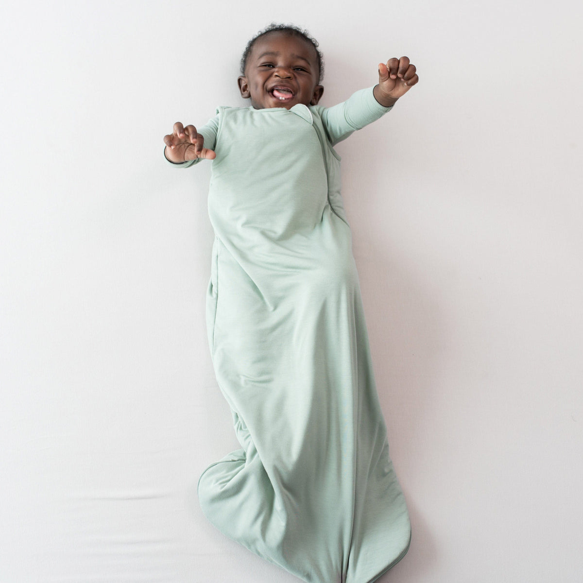 Infant wearing Kyte Baby Sleep Bag in Thyme 1.0