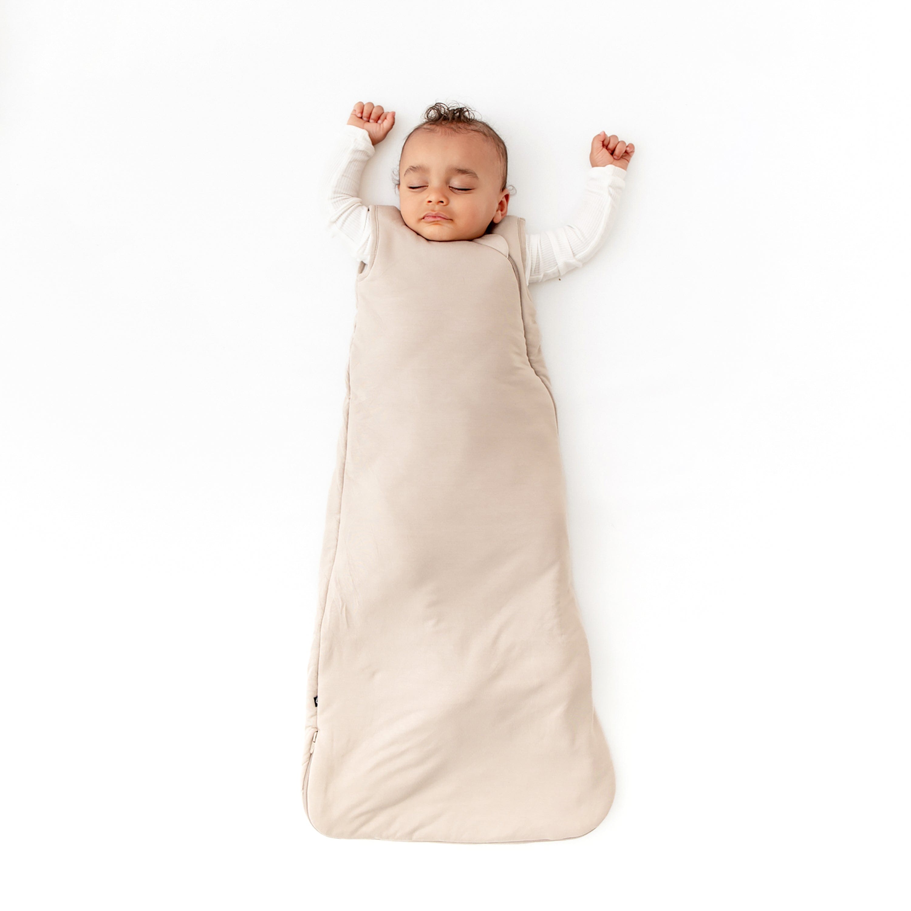 Baby wearing 2.5 TOG Sleep Bag in Almond with a Cloud long sleeve romper