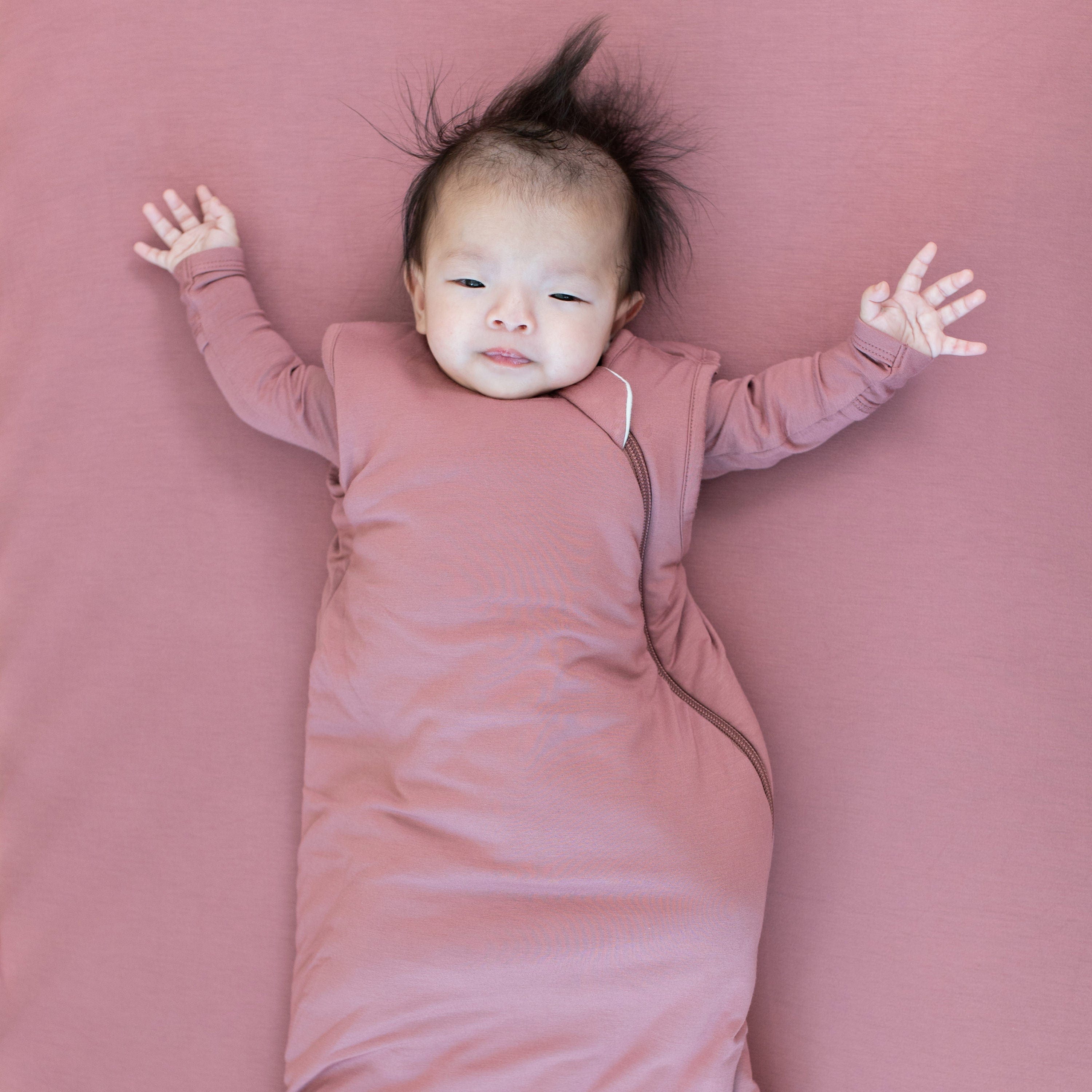Infant wearing Kyte Baby Sleep Bag in Dusty Rose 2.5