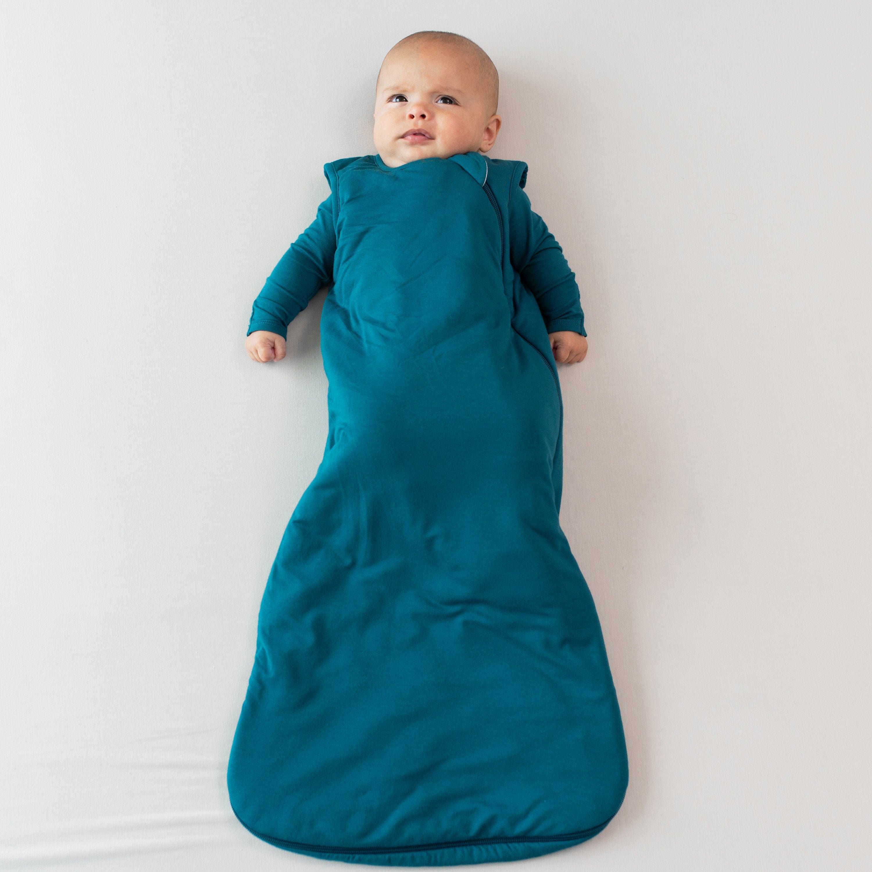 Infant wearing the 2.5 Sleep Bag in Loch with a Loch long sleeve romper underneath