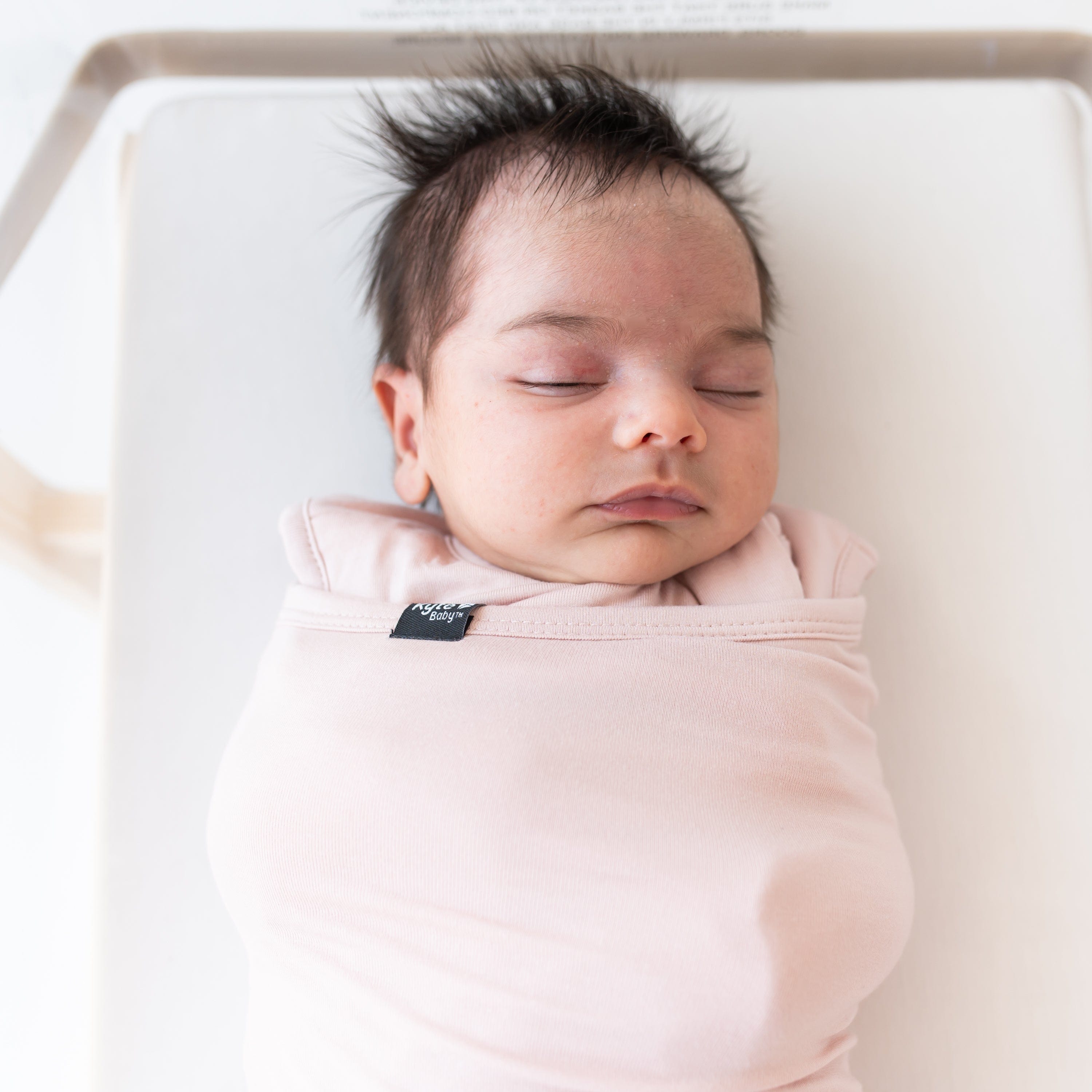 Close up of sleeping baby swaddled in the Sleep Bag Swaddler in Blush 1.0