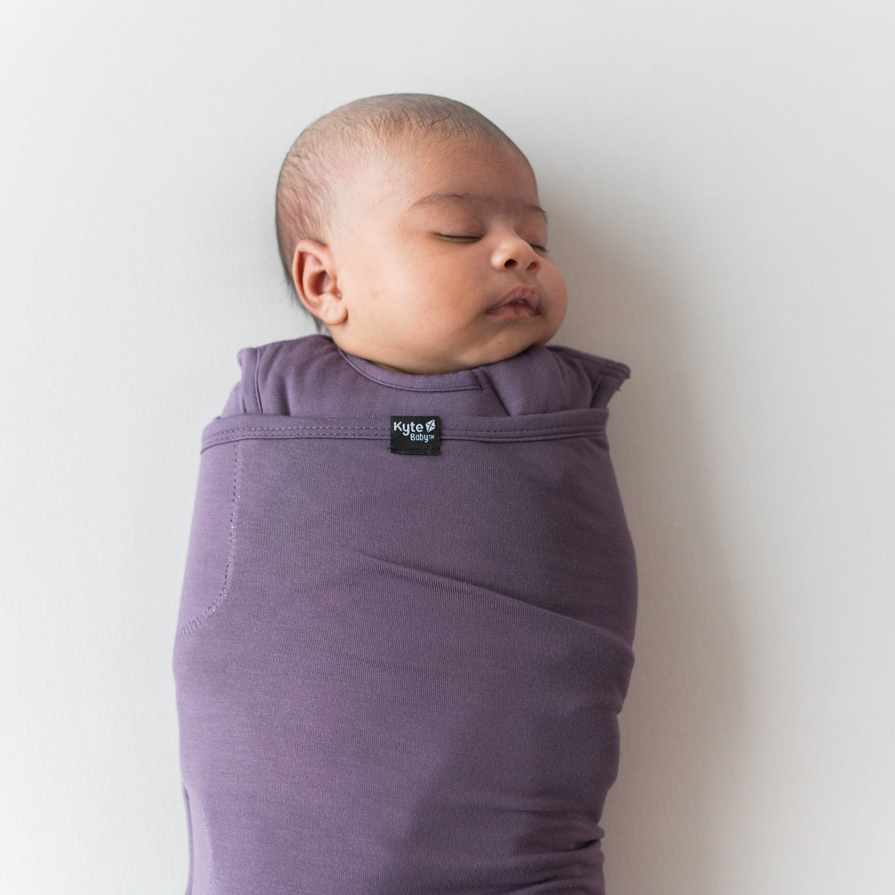 Baby swaddled in the Sleep Bag Swaddler in Currant TOG 1.0