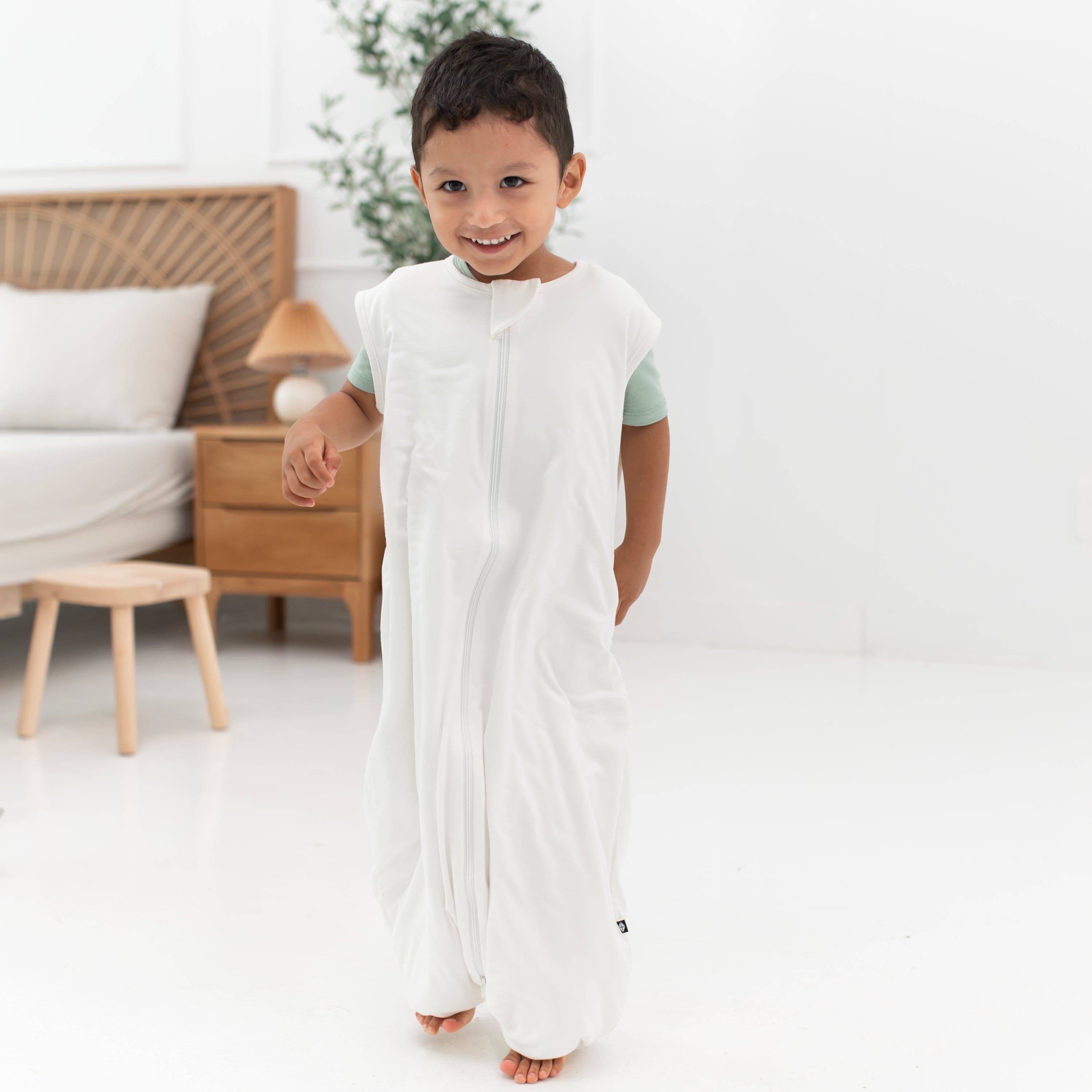 Smiling model wearing the Sleep Bag Walker in Cloud 0.5