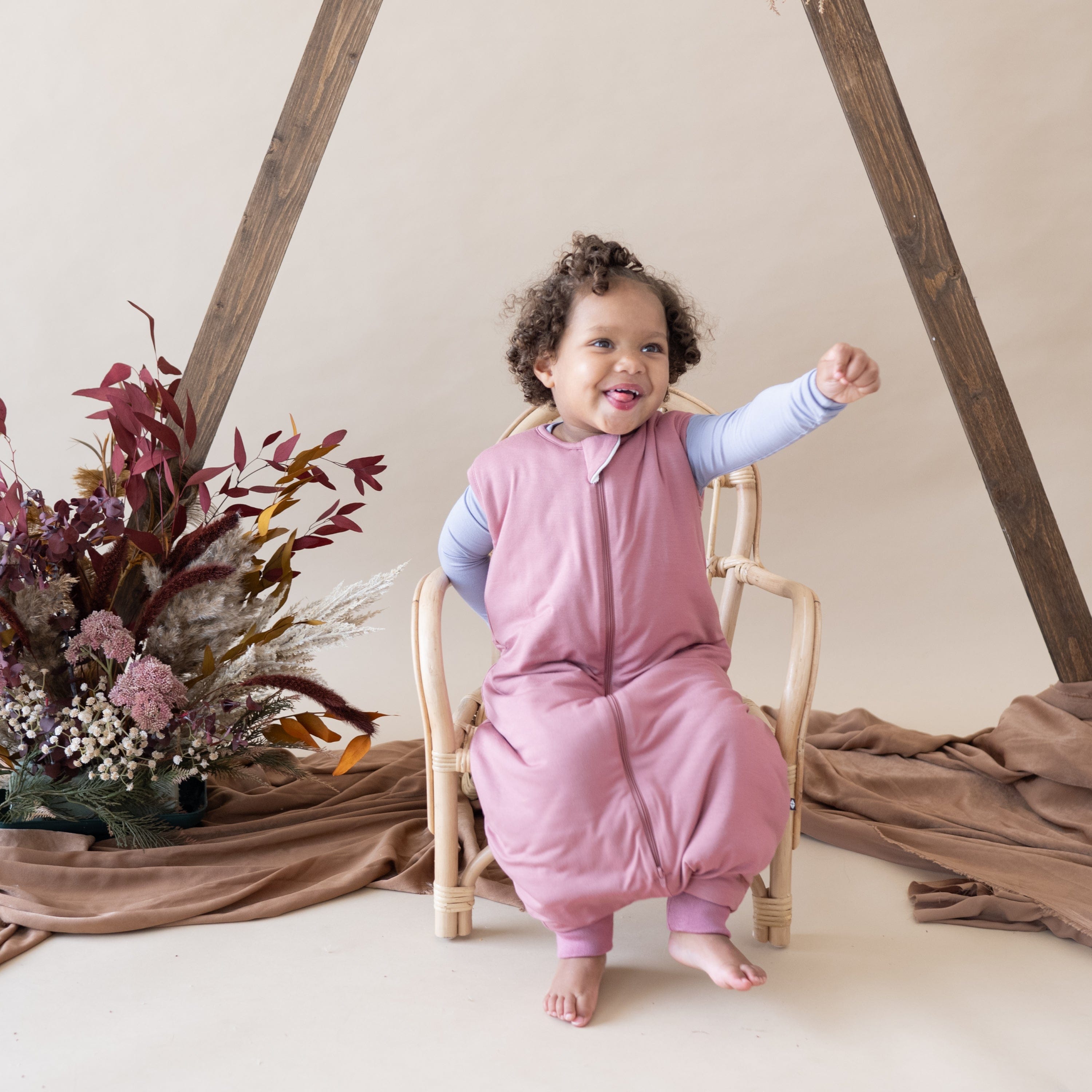 Child wearing Kyte Baby bamboo TOG 1.0 Sleep Bag Walker in Dusty Rose