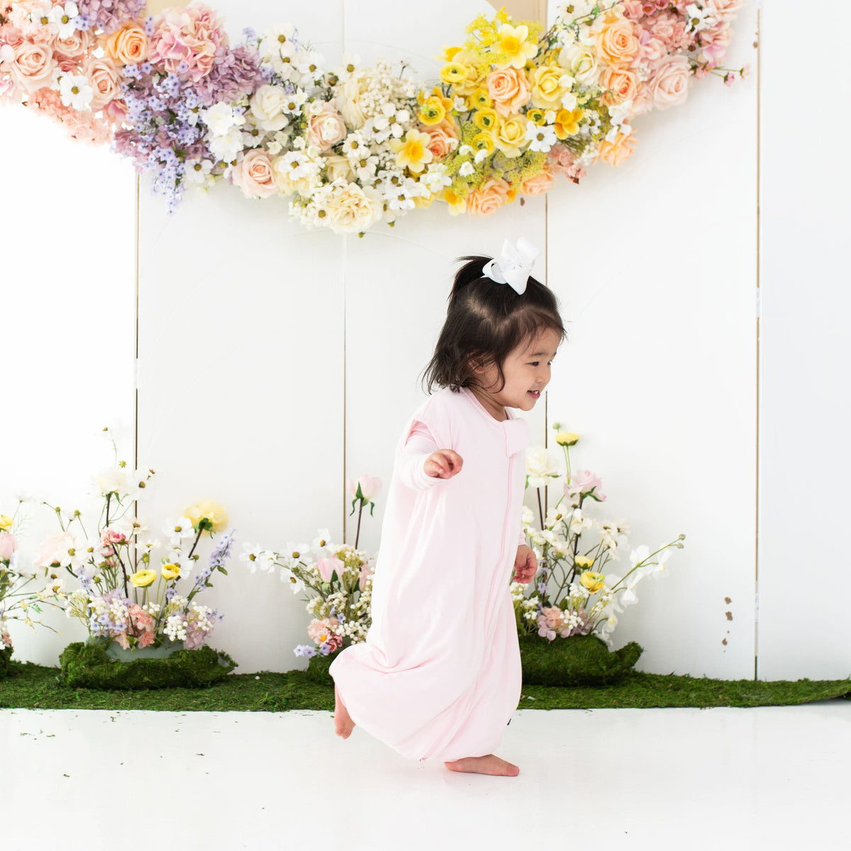 Toddler wearing Kyte Baby Sleep Bag Walker in Sakura 1.0