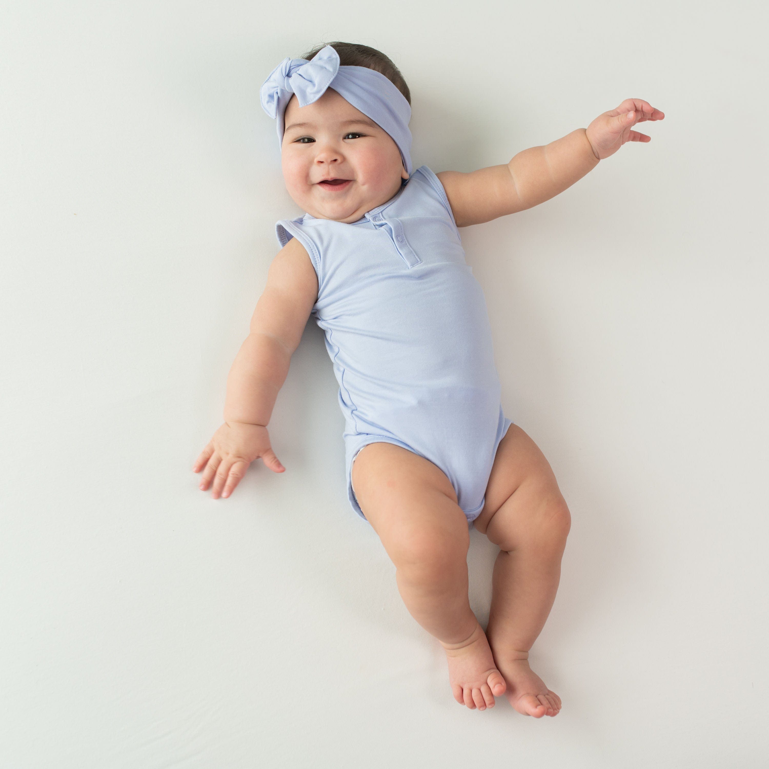 Baby wearing Kyte Baby Sleeveless infant Bodysuit in Lilac