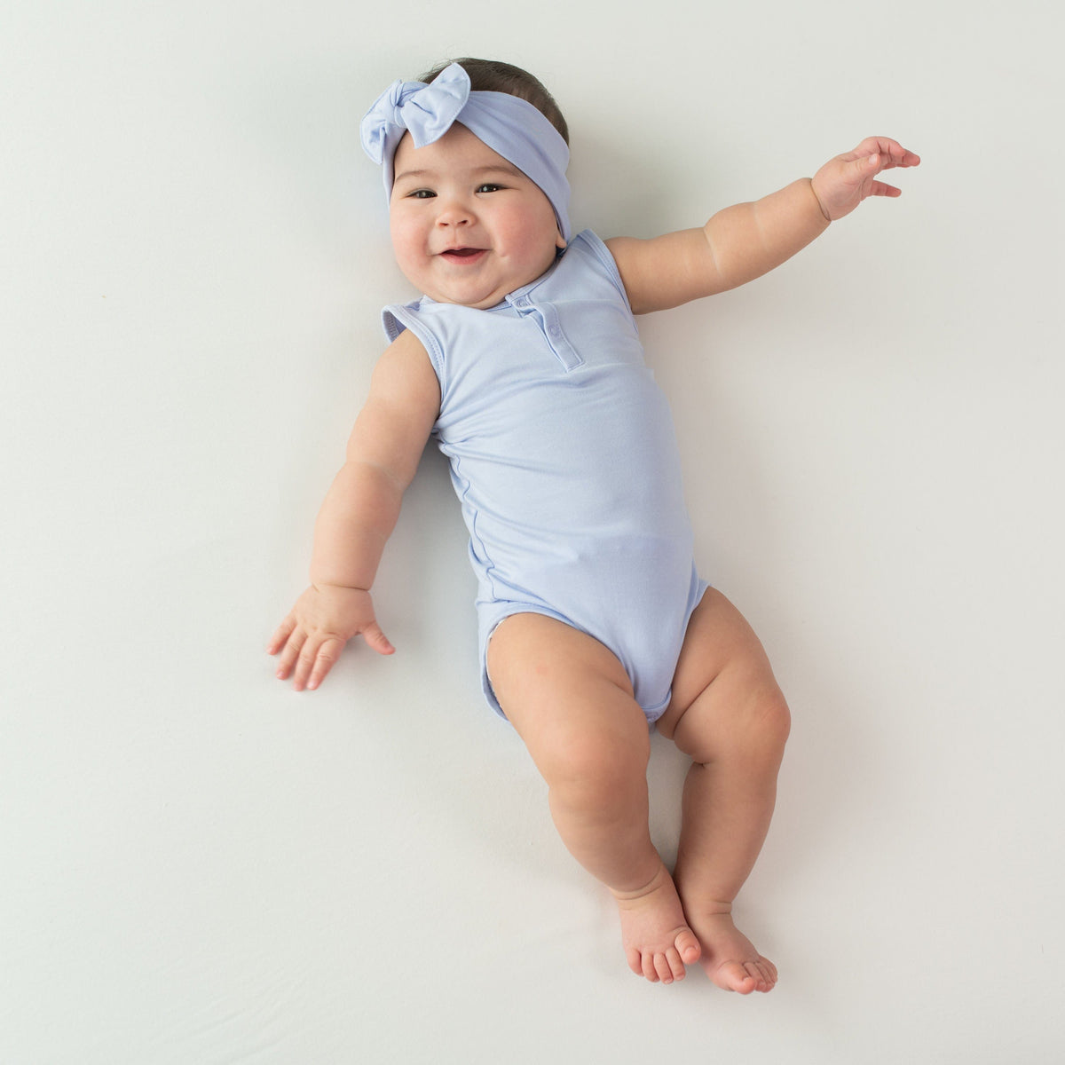 Baby wearing Kyte Baby Sleeveless infant Bodysuit in Lilac