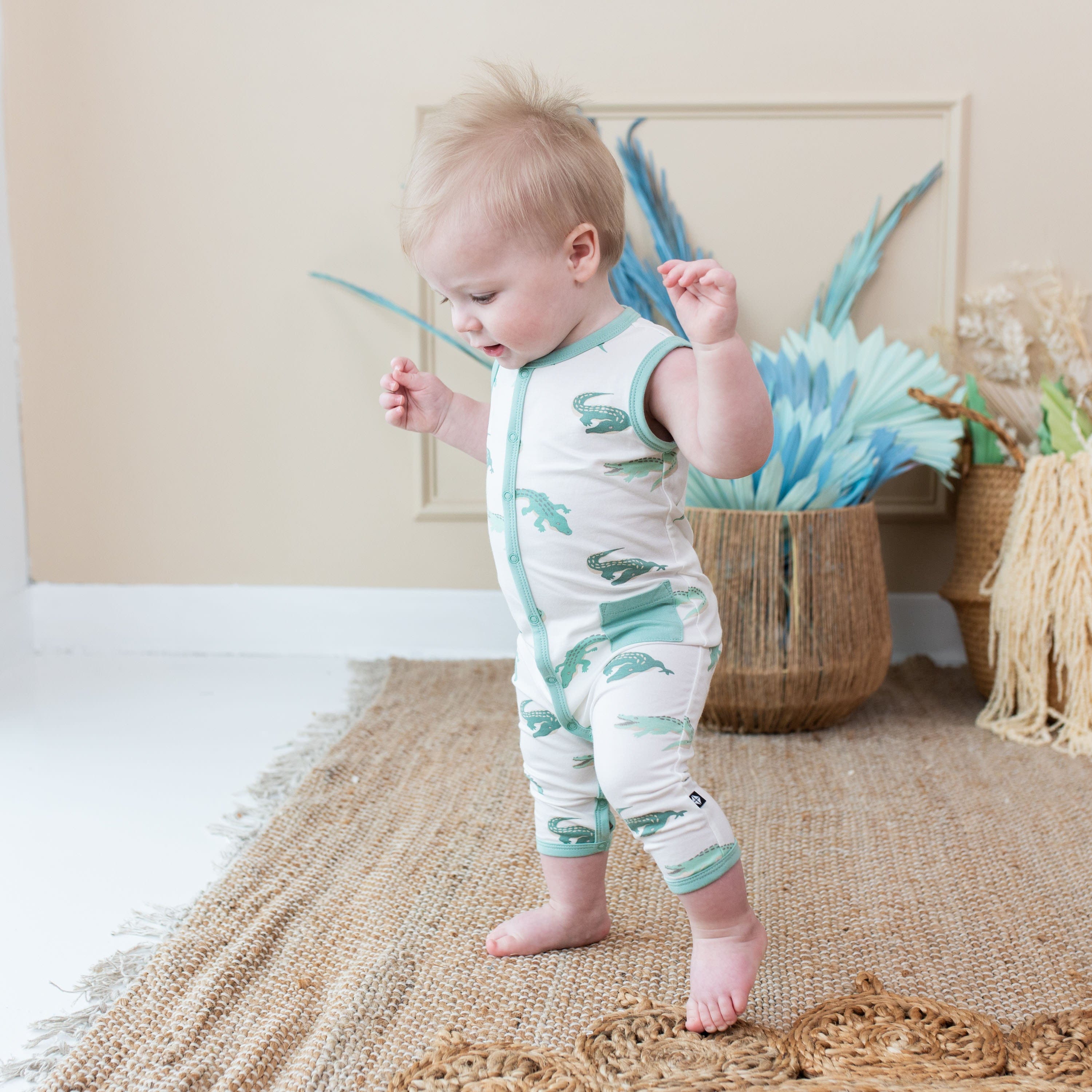Child wearing bamboo Kyte Baby Sleeveless Romper in Crocodile