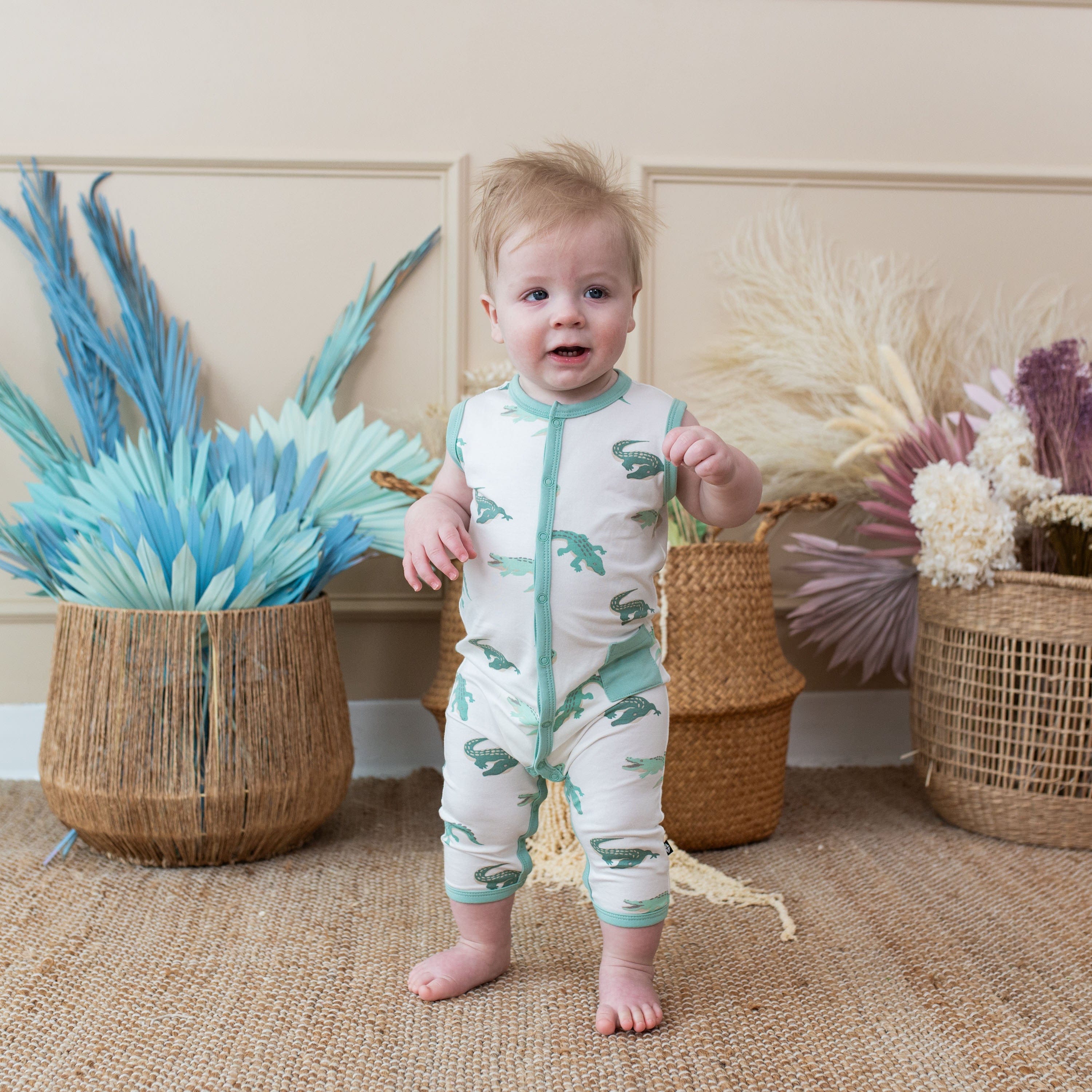 Toddler wearing Kyte Baby Sleeveless capri Romper in Crocodile
