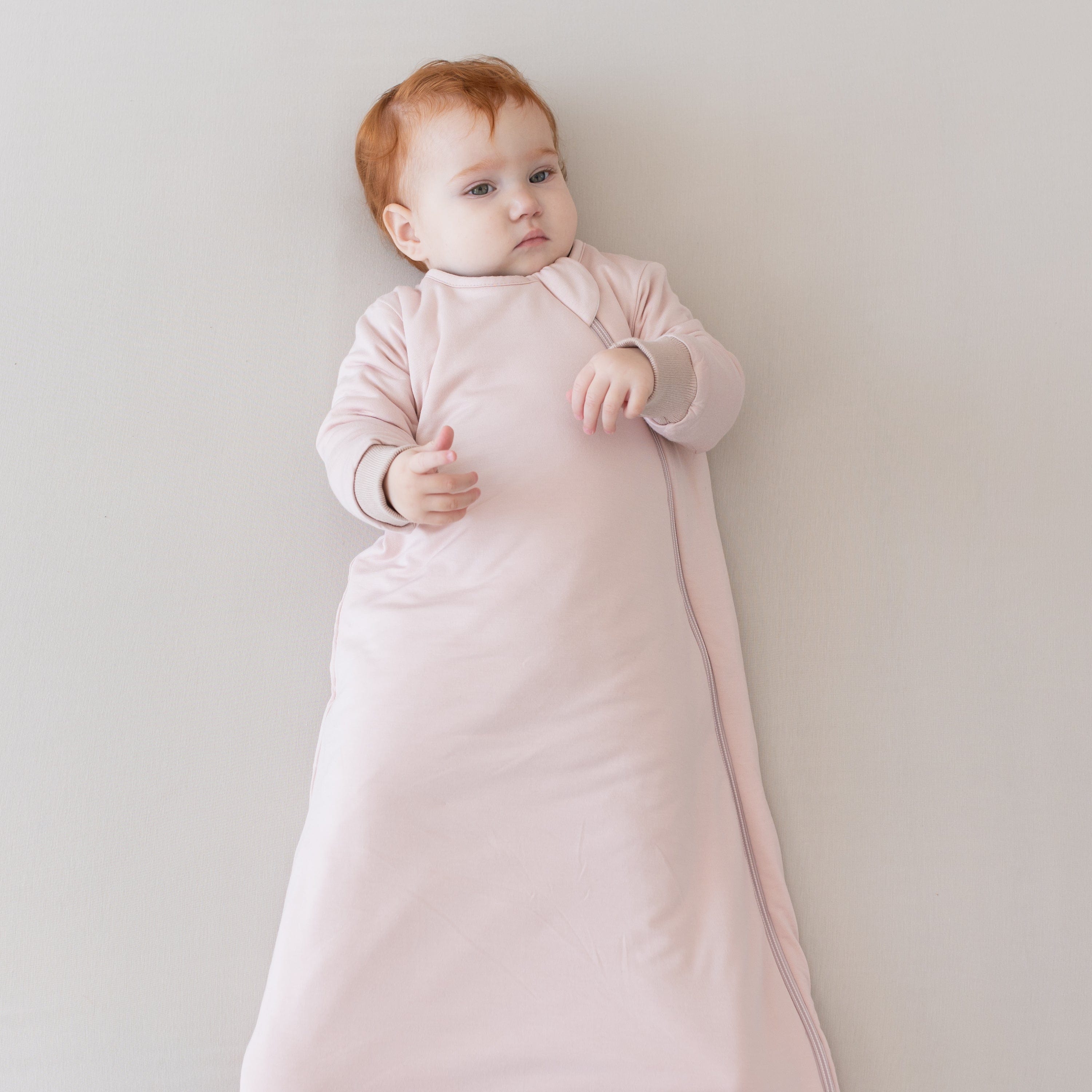 Child wearing Kyte Baby Slumber Bag in Blush