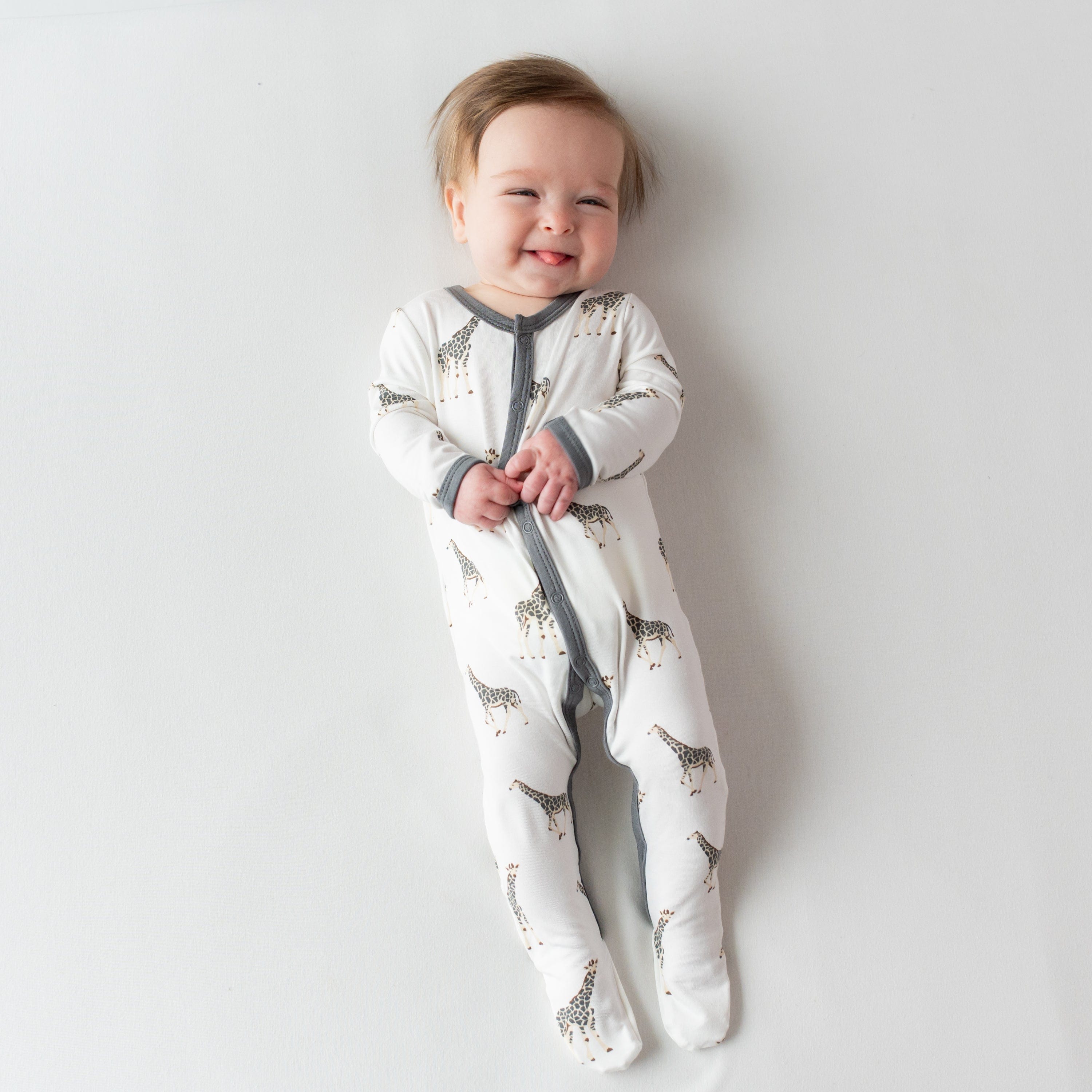 Infant wearing Kyte Baby Snap Footie in Giraffe