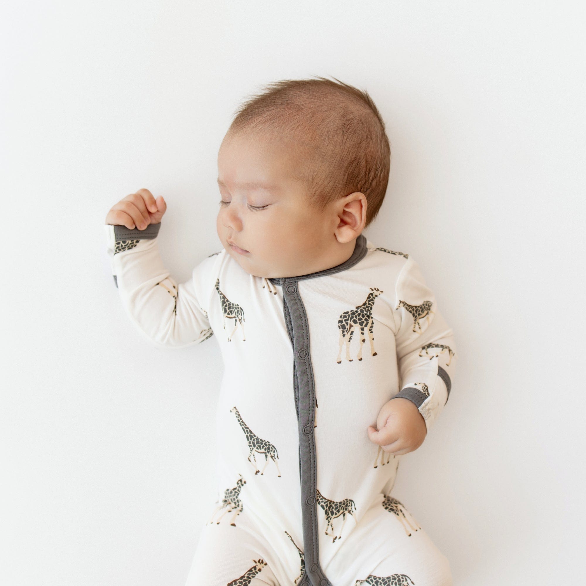 Newborn wearing Kyte Baby Footie in Giraffe