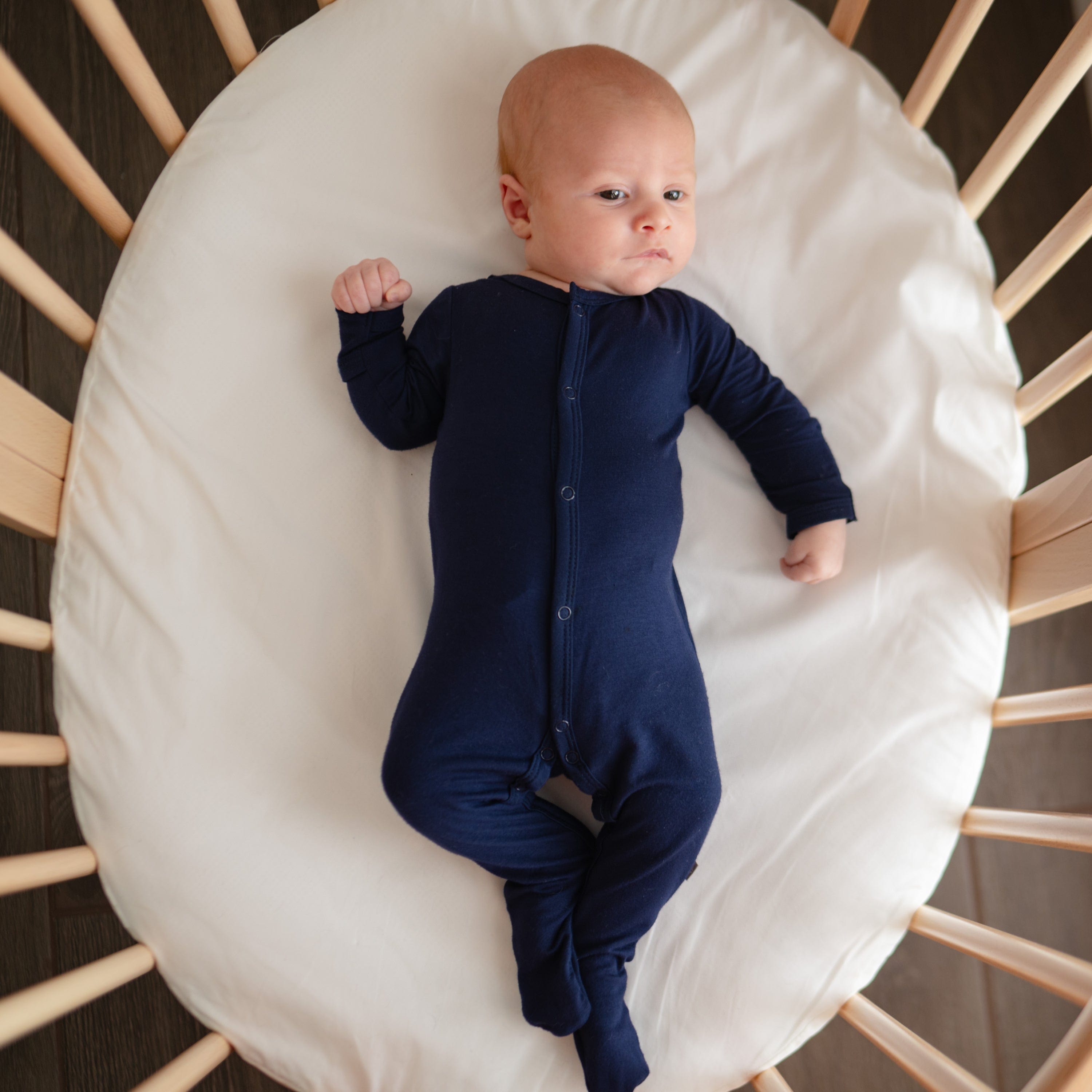 Baby wearing Kyte Baby Snap Footie in Navy