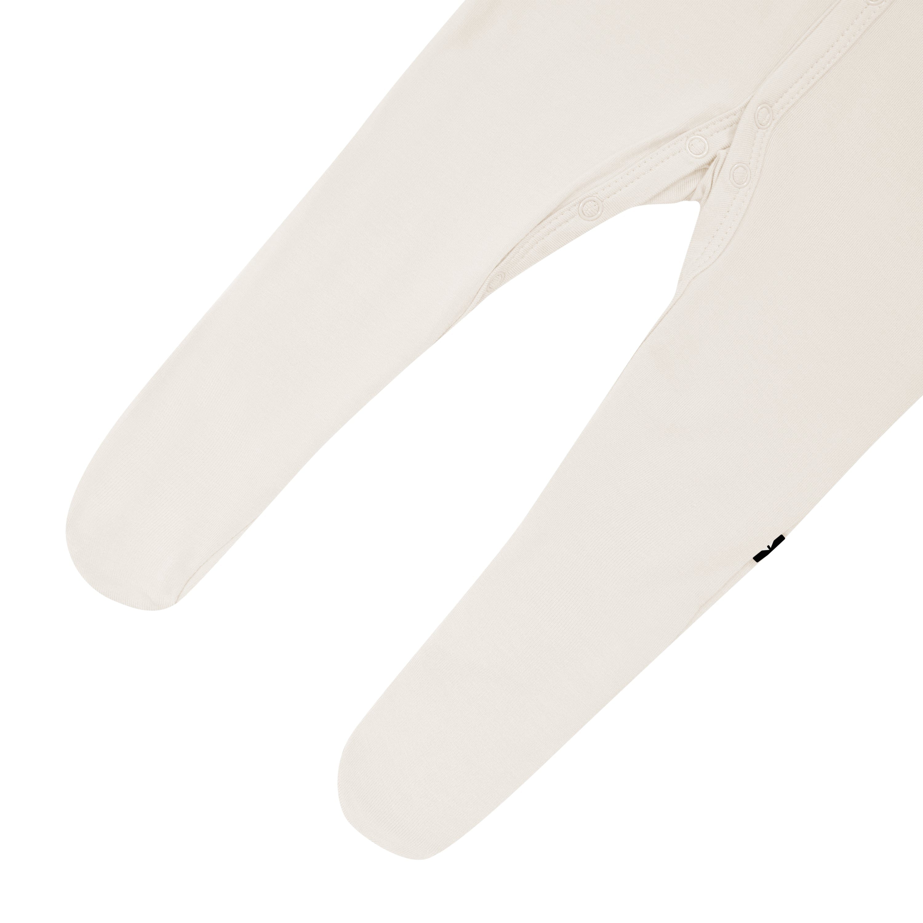 Close up of footed legs and snaps on Kyte Baby Footie in Oat