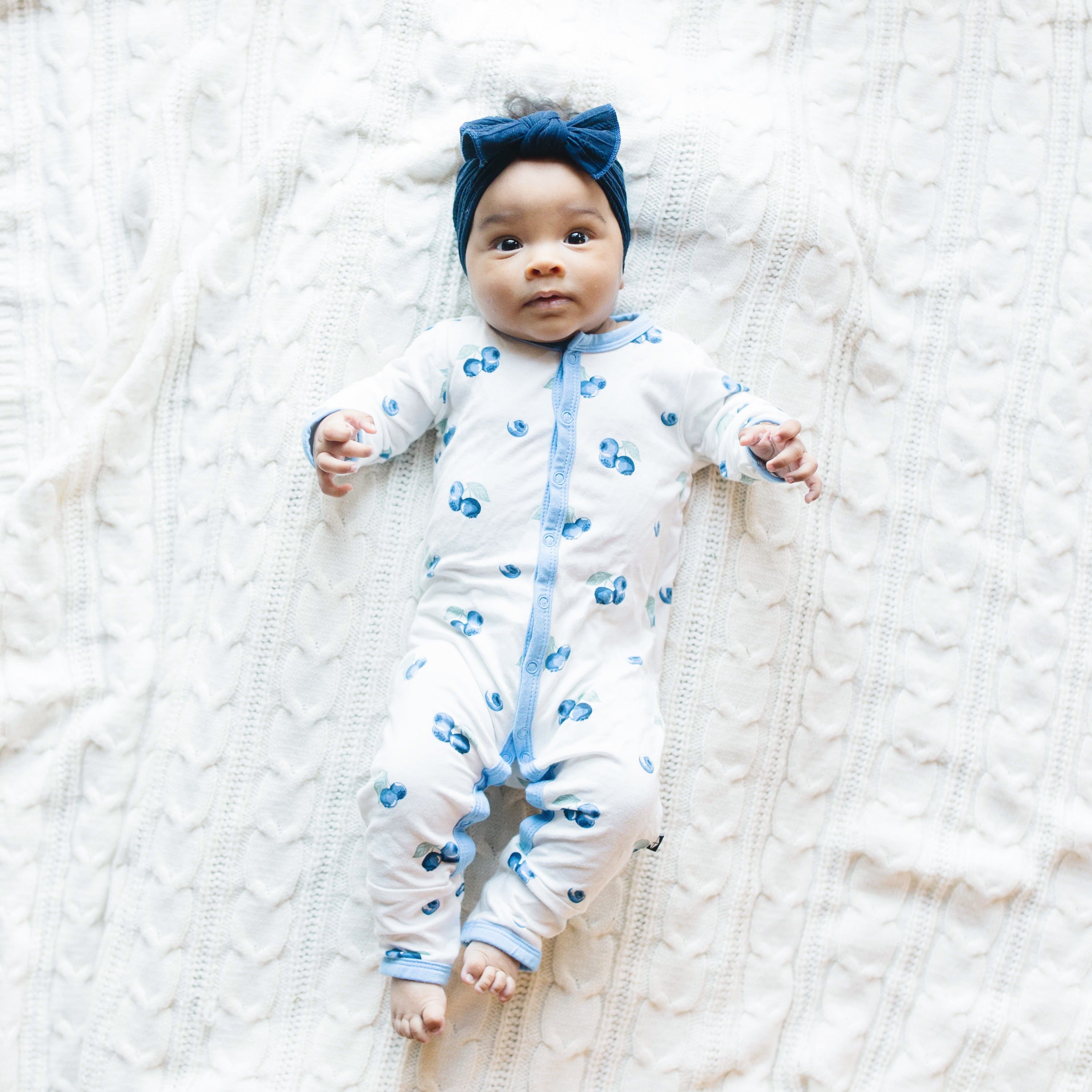Child wearing long sleeve Kyte Baby Romper with snaps in Blueberry