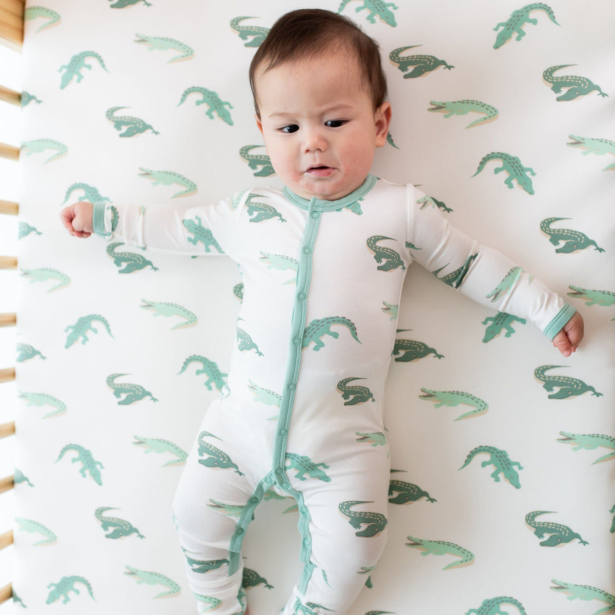 Infant wearing Kyte Baby Romper in Crocodile