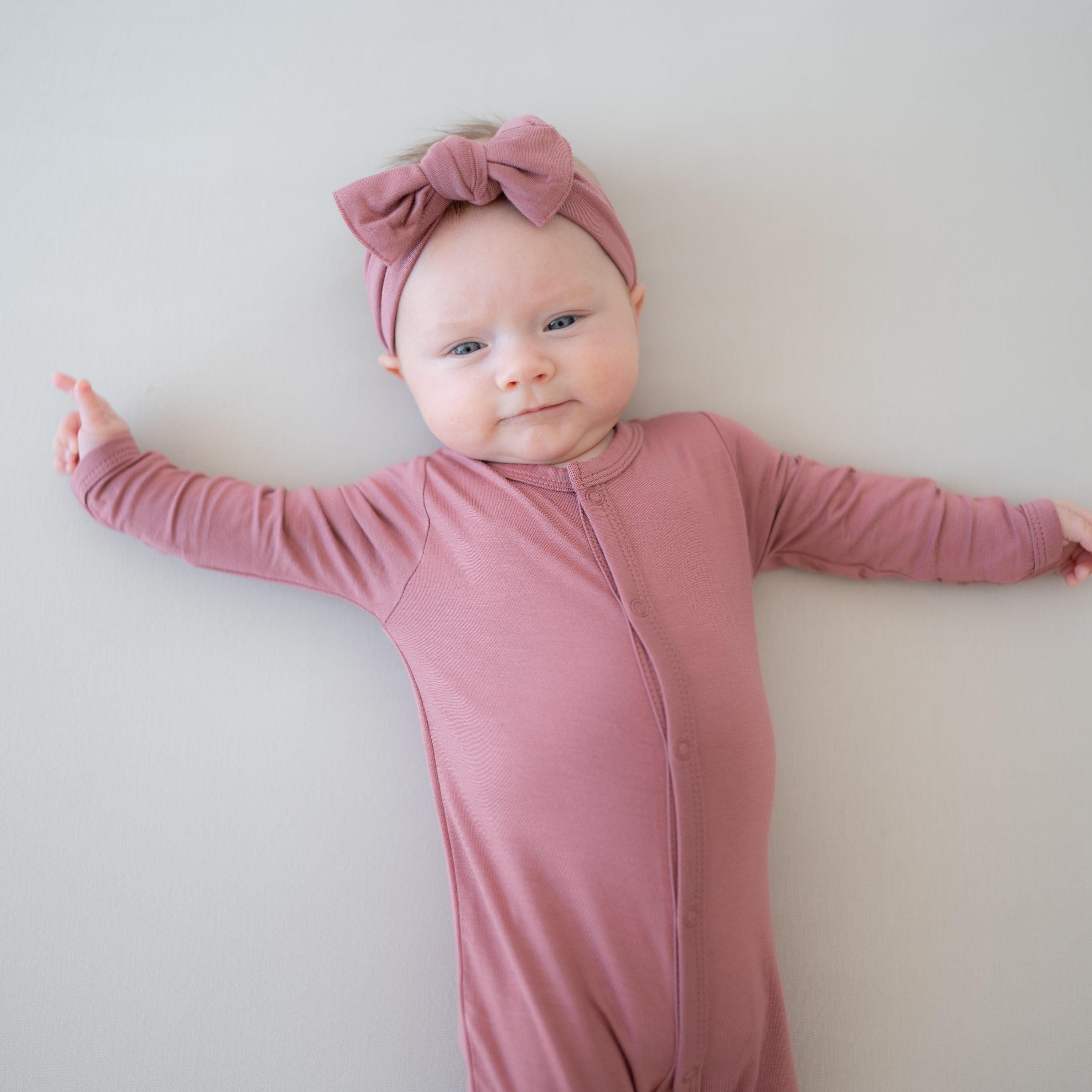 Infant wearing Kyte Baby Romper in Dusty Rose