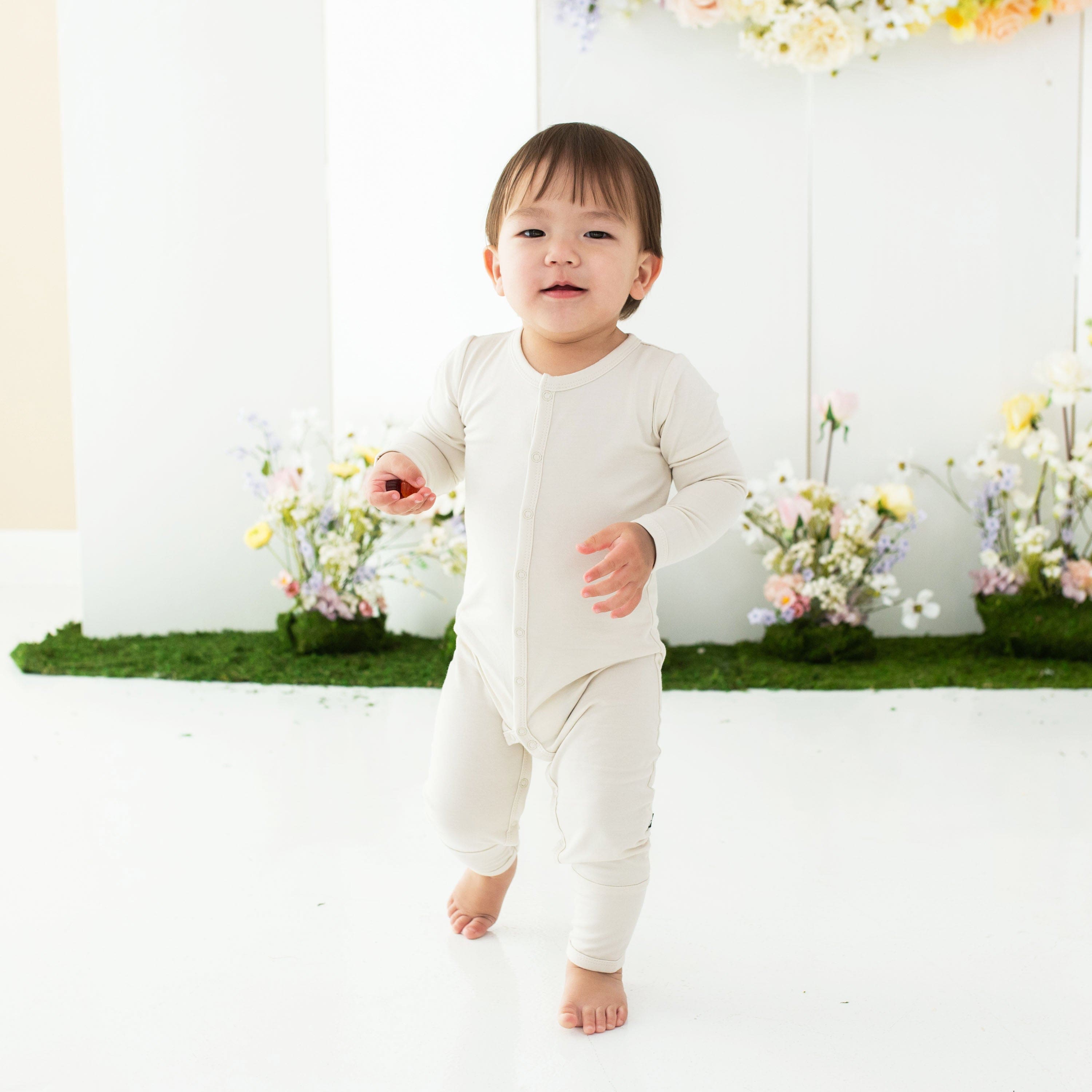 Toddler wearing Kyte Baby Romper in Ecru