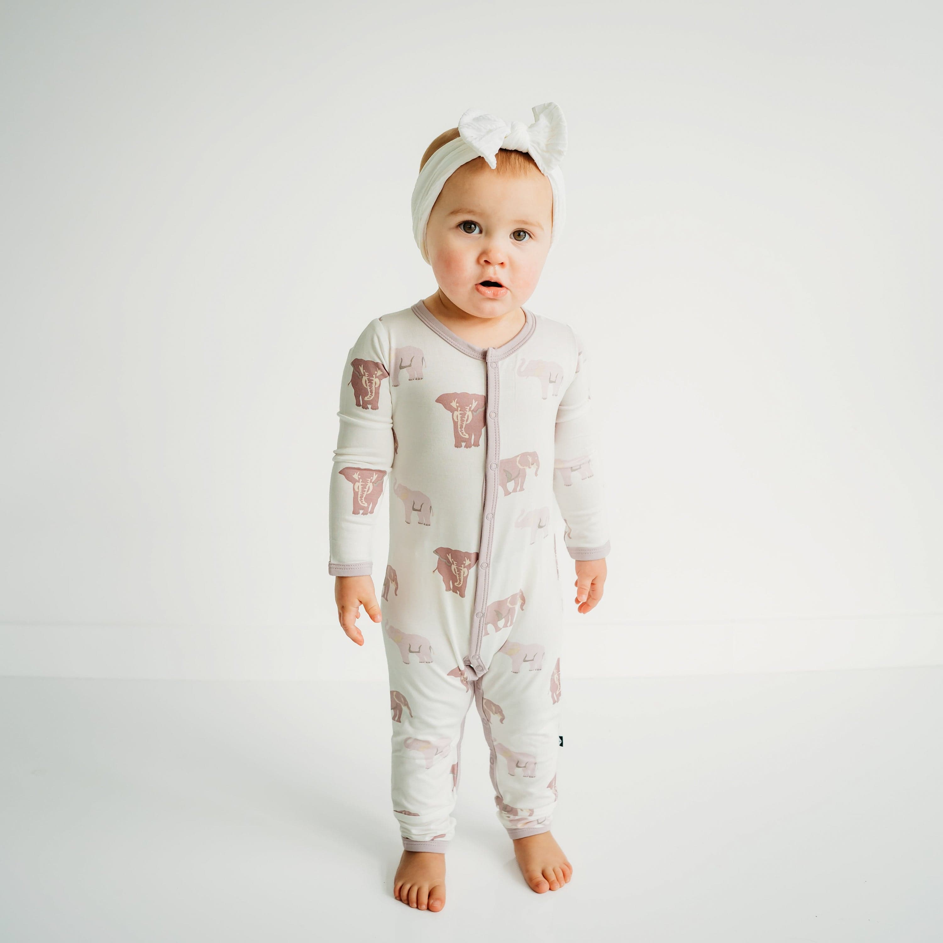 Child wearing long sleeve Kyte Baby Romper with snaps in Elephant