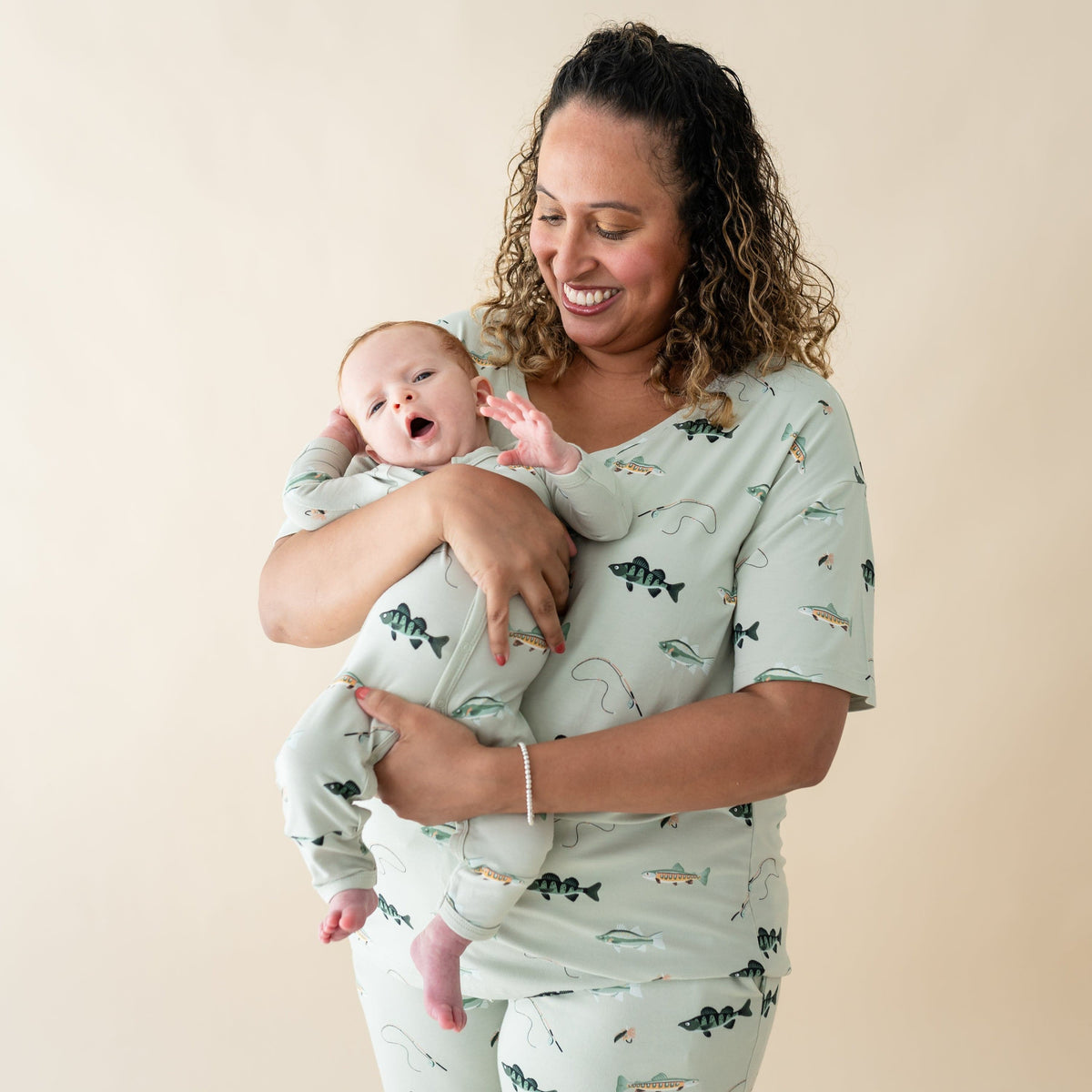 Woman wearing Kyte Baby Women's Relaxed Fit V-Neck in Fishing with Infant in matching romper