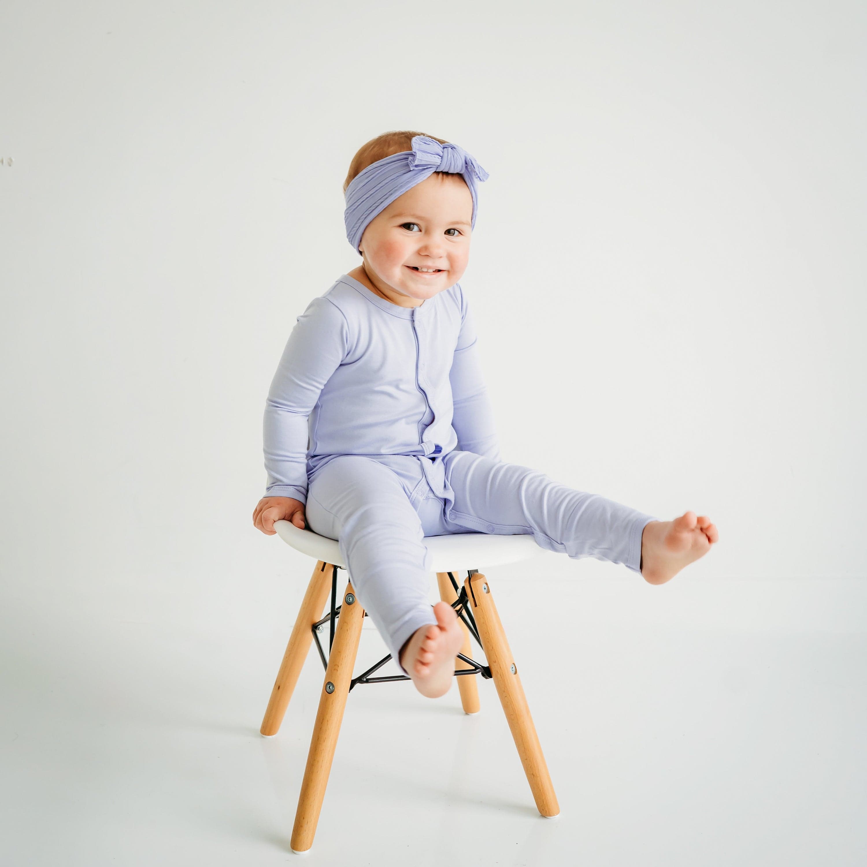 Child wearing long sleeve Kyte Baby Romper with snaps in Lilac