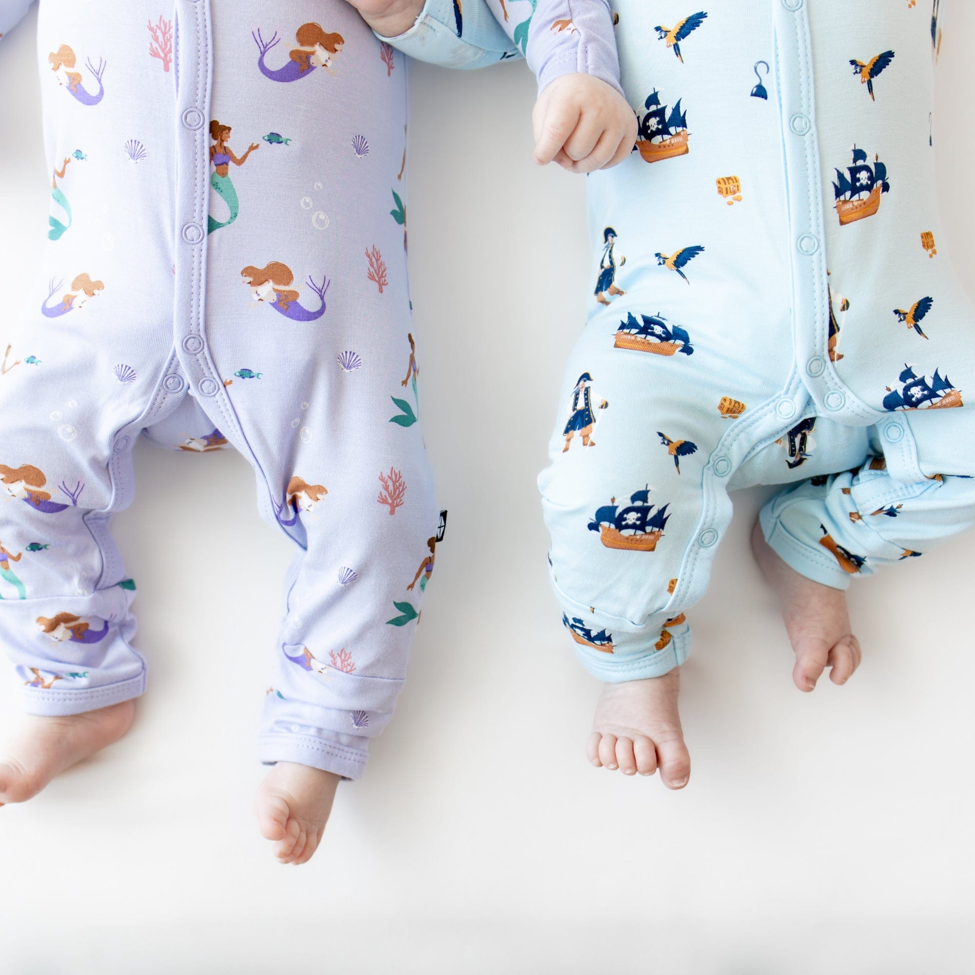 Infants wearing Kyte Baby Rompers in Mermaid and Pirate