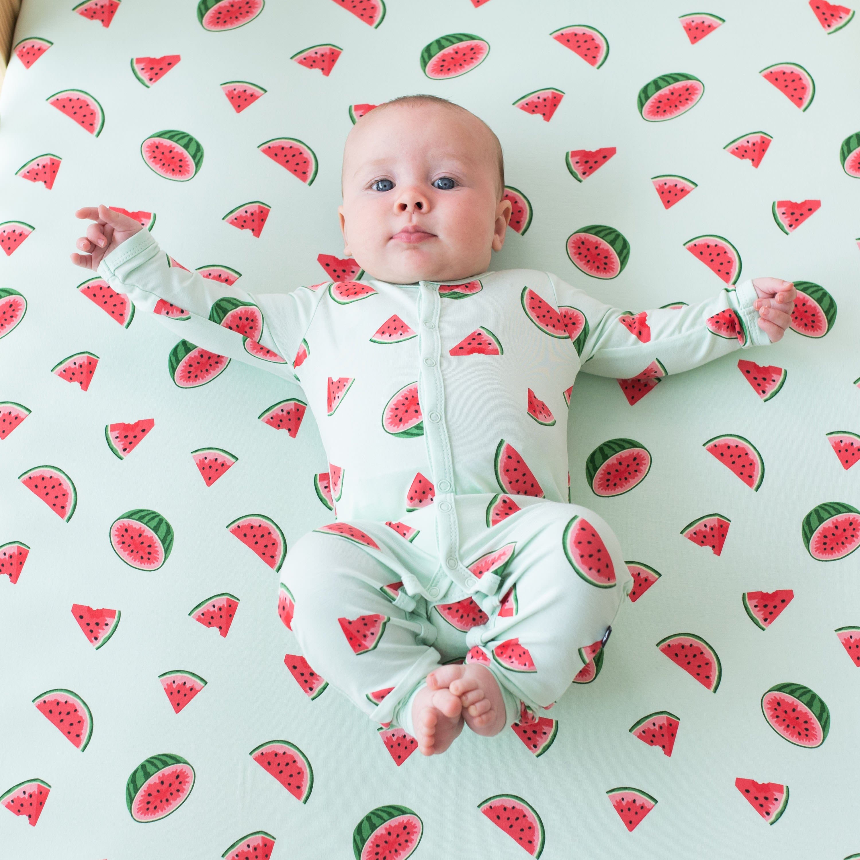 Child wearing long sleeve Kyte Baby Romper with snaps in Watermelon