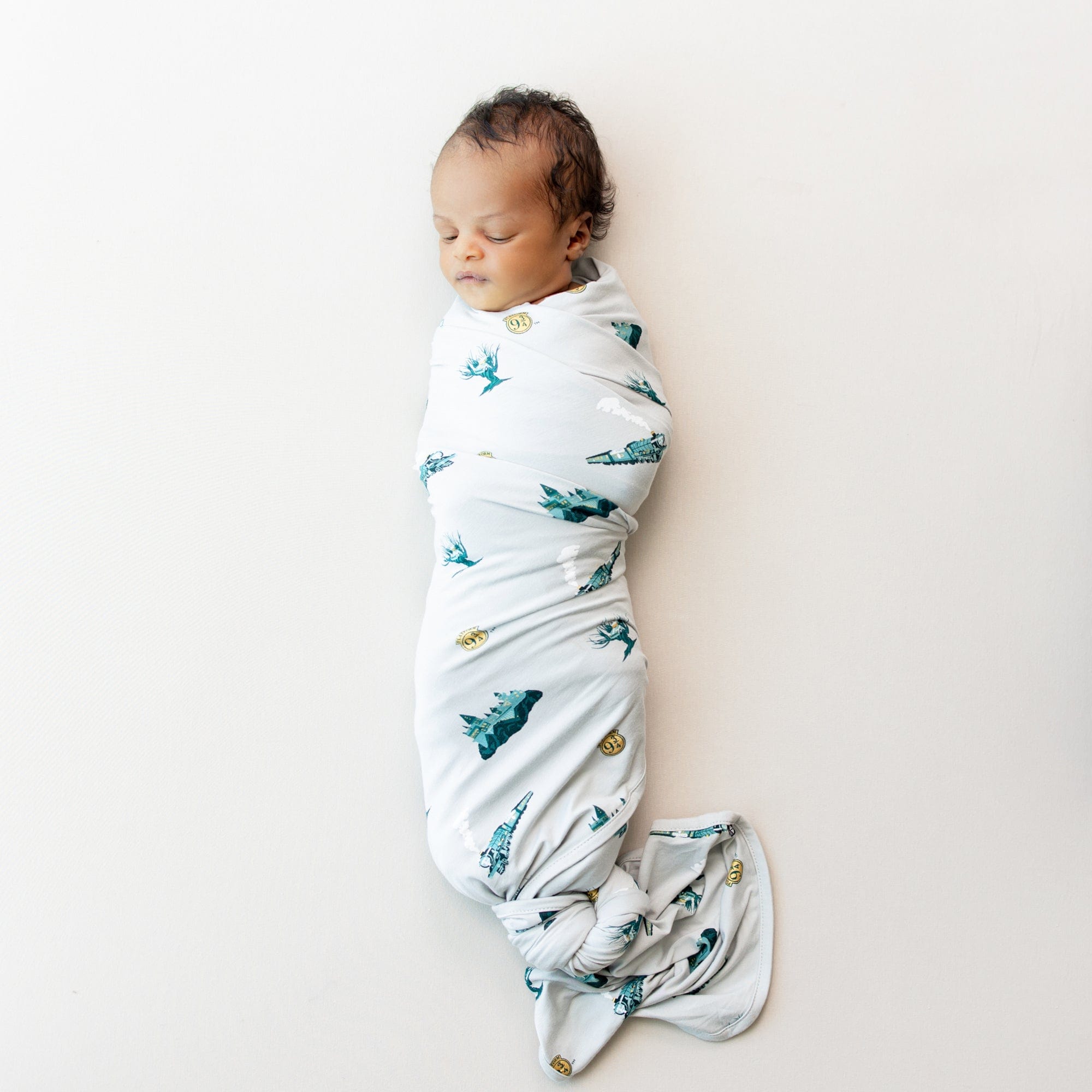 Newborn sleeping in Kyte Baby Swaddle Blanket in Journey