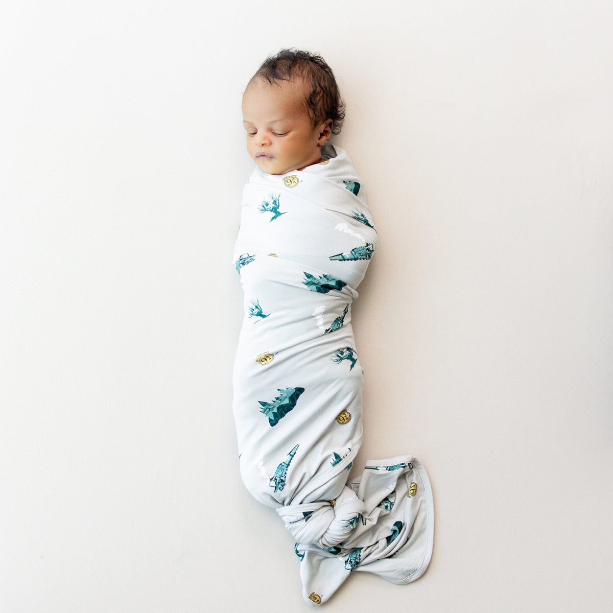 Newborn sleeping in Kyte Baby Swaddle Blanket in Journey