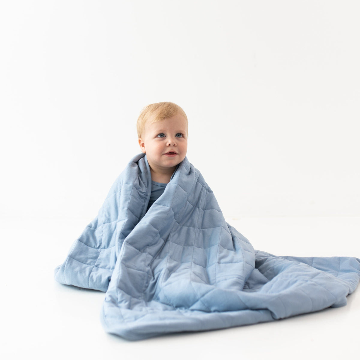 Child wrapped in Kyte Baby Toddler Blanket in Slate 1.0