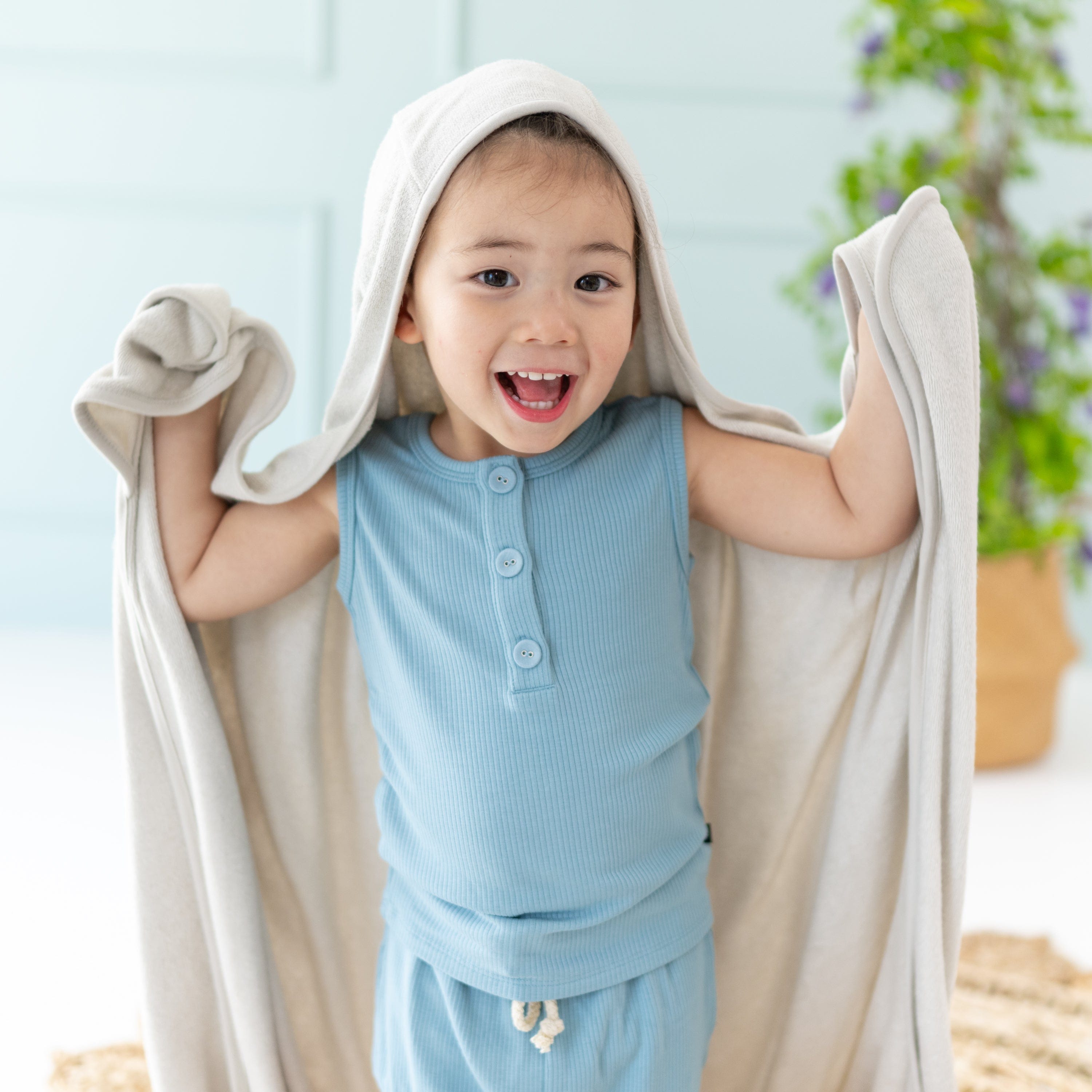 Child wrapped in Kyte Baby Toddler Hooded Bath Towel in Oat
