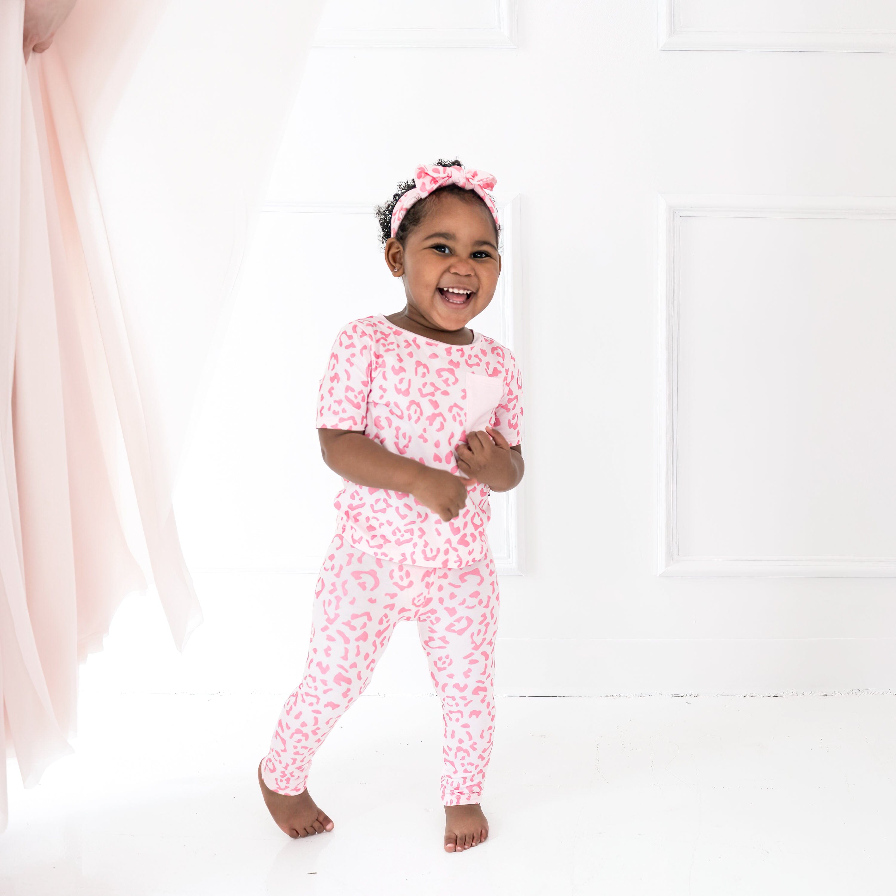 Girl wearing Kyte Baby Toddler Leggings in Sakura Leopard
