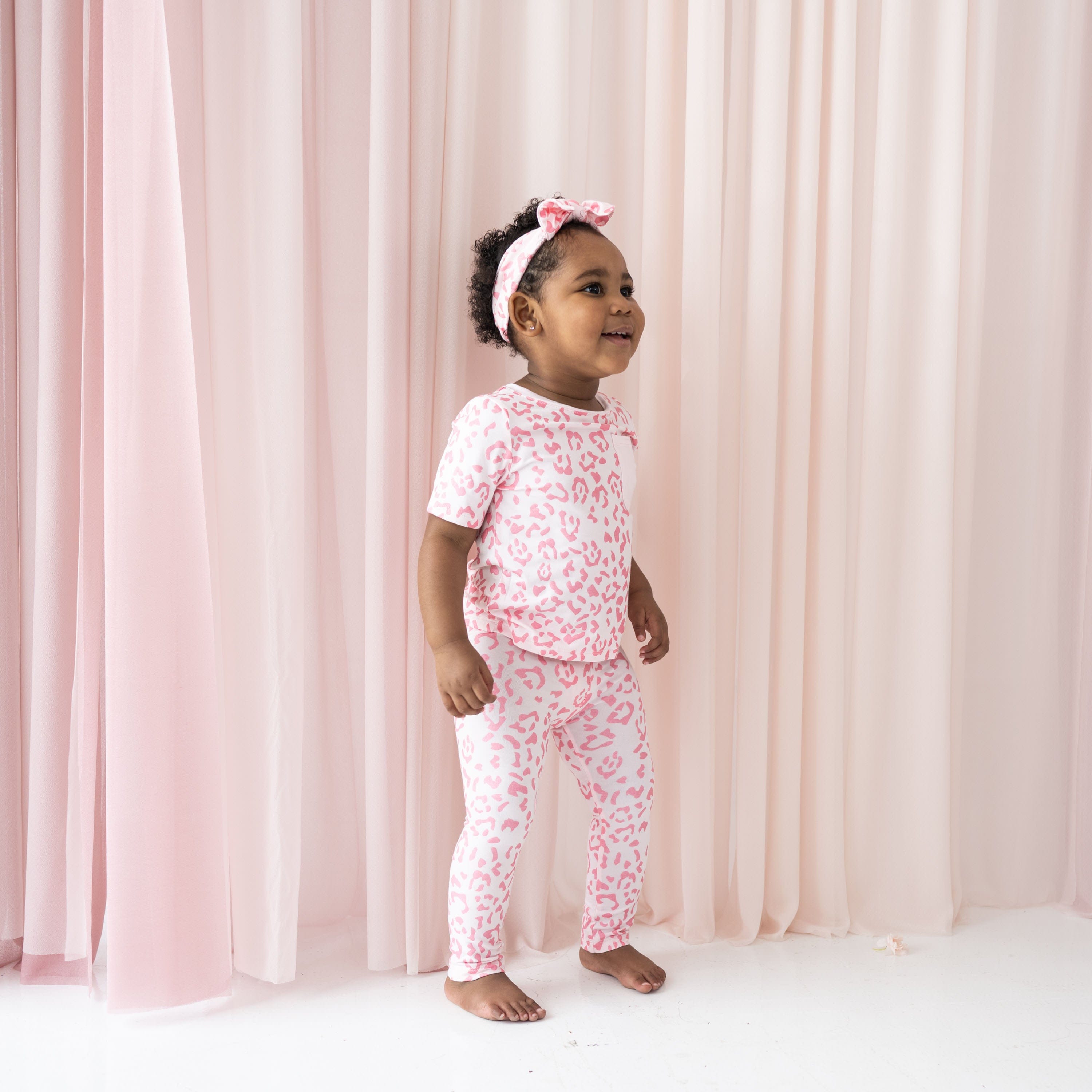 Child wearing Kyte Baby Bamboo Toddler Leggings in Sakura Leopard