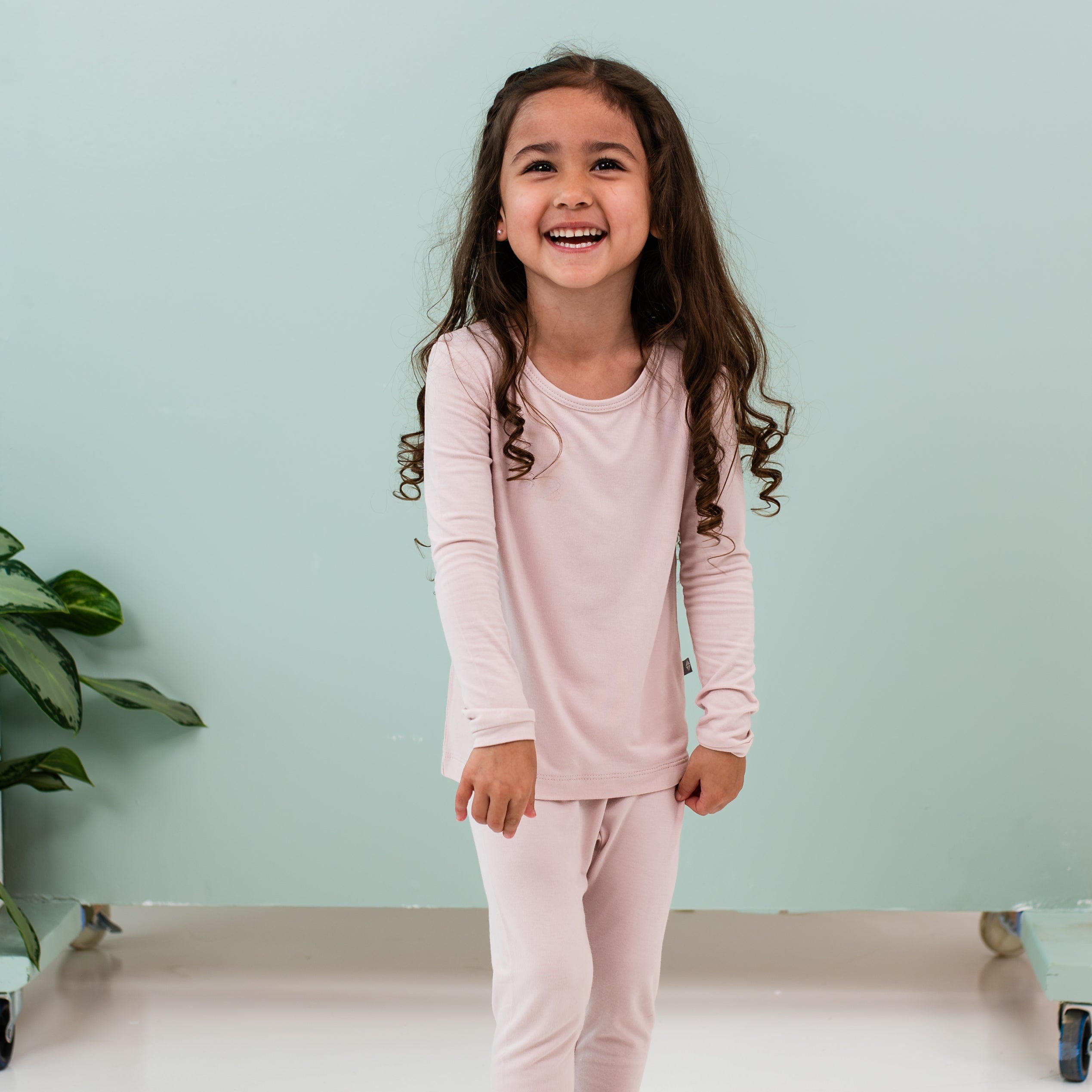 Child wearing Kyte Baby Long Sleeve Pajamas in Blush