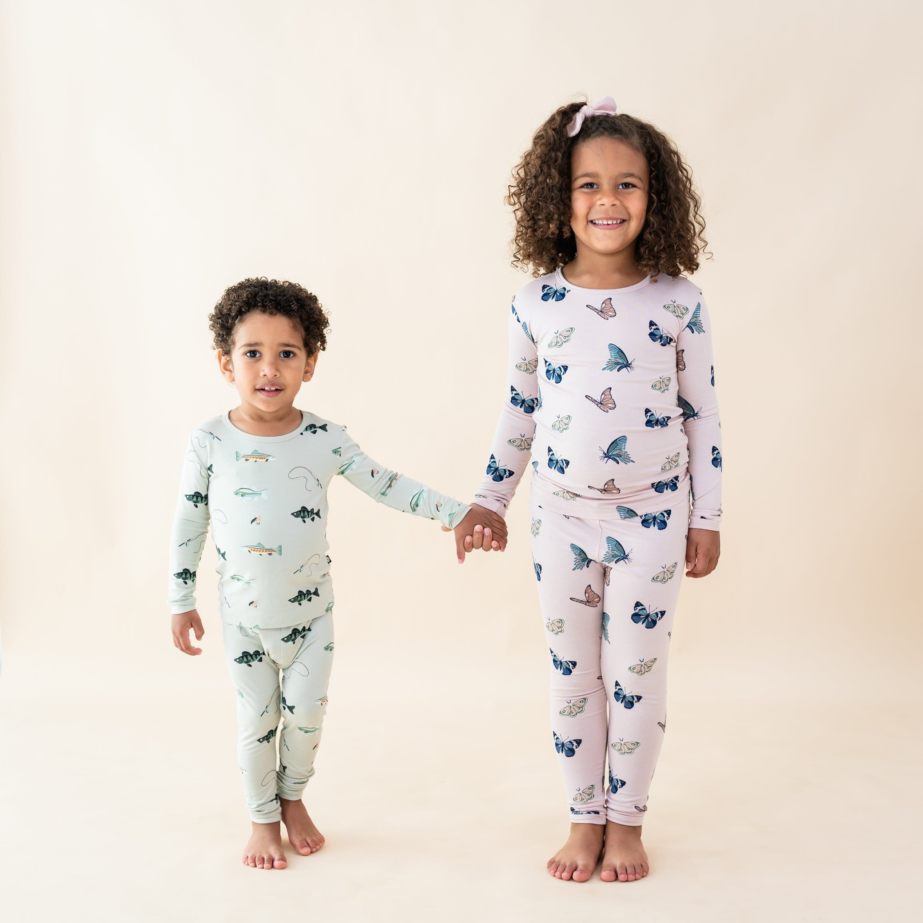 Kids wearing long sleeve pajama sets in fish and butterfly prints
