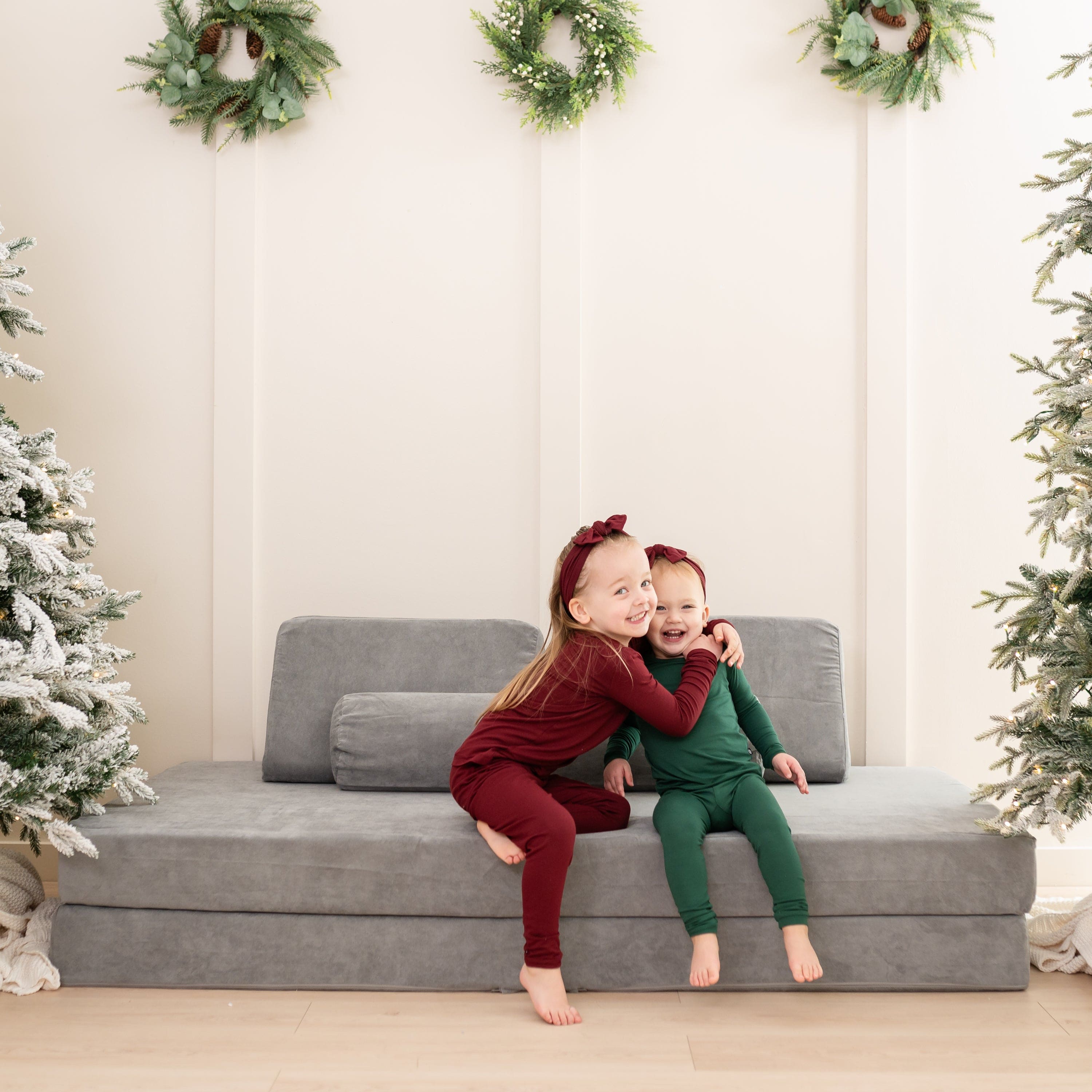 Siblings wearing Long Sleeve Christmas Pajamas in red and green