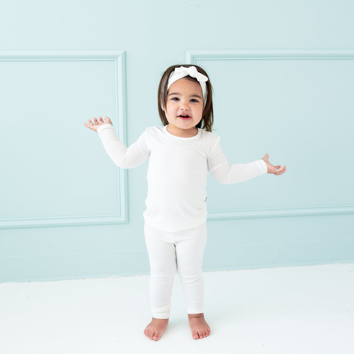 Toddler wearing Long Sleeve Pajamas in Cloud and matching bow headband