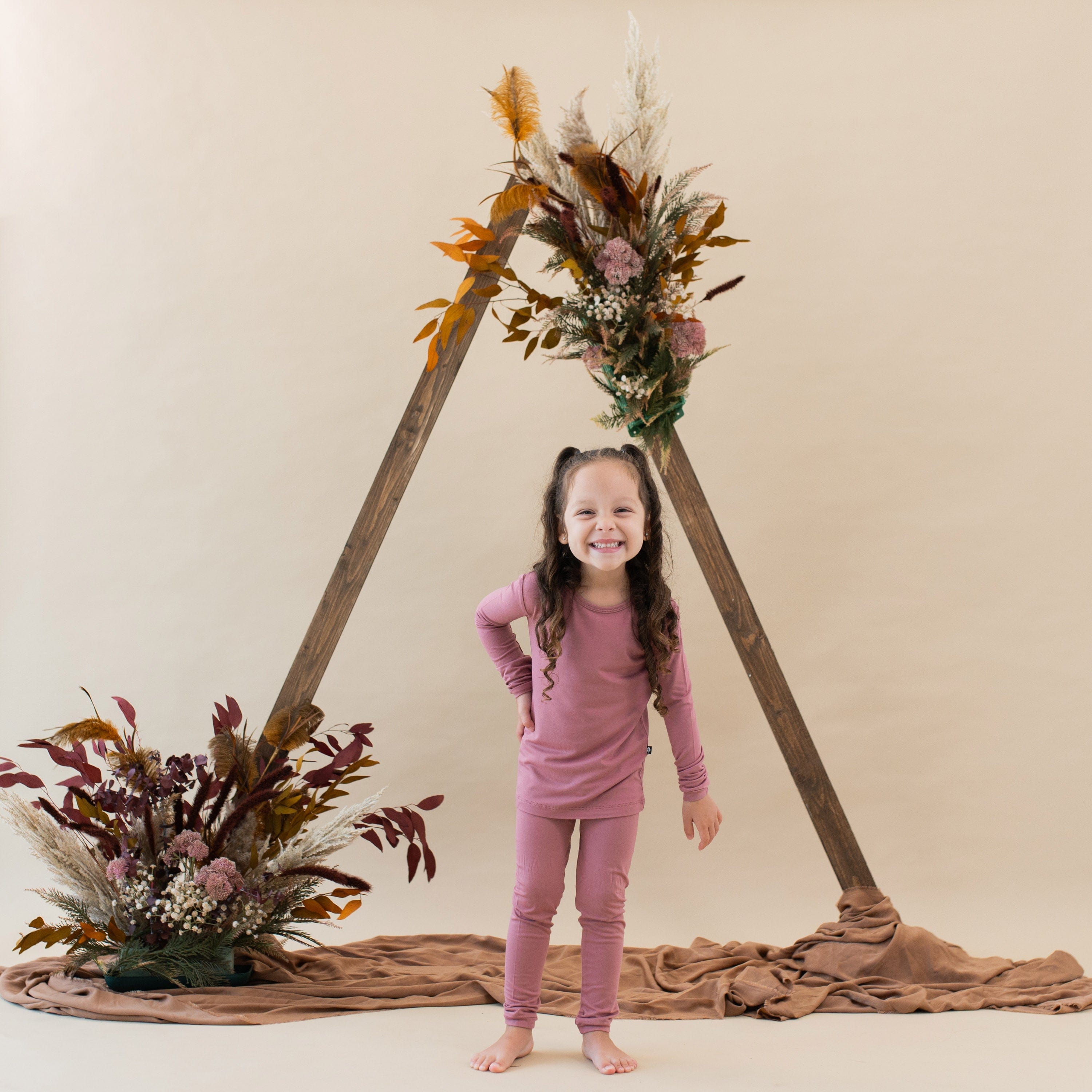 Child wearing Kyte Baby Long Sleeve Pajamas in Dusty Rose