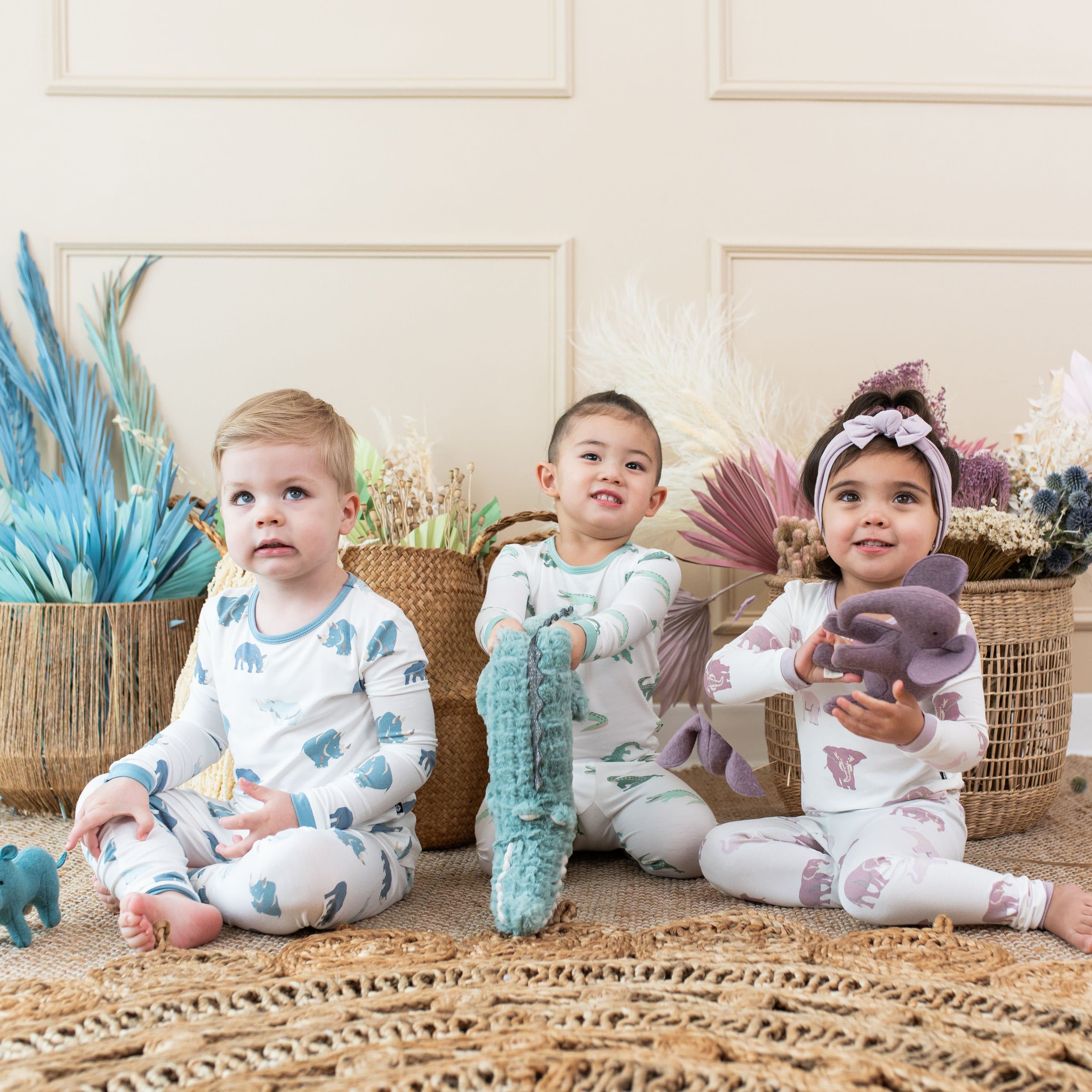 Children wearing Kyte Baby long sleeve kids pajamas with animal patterns