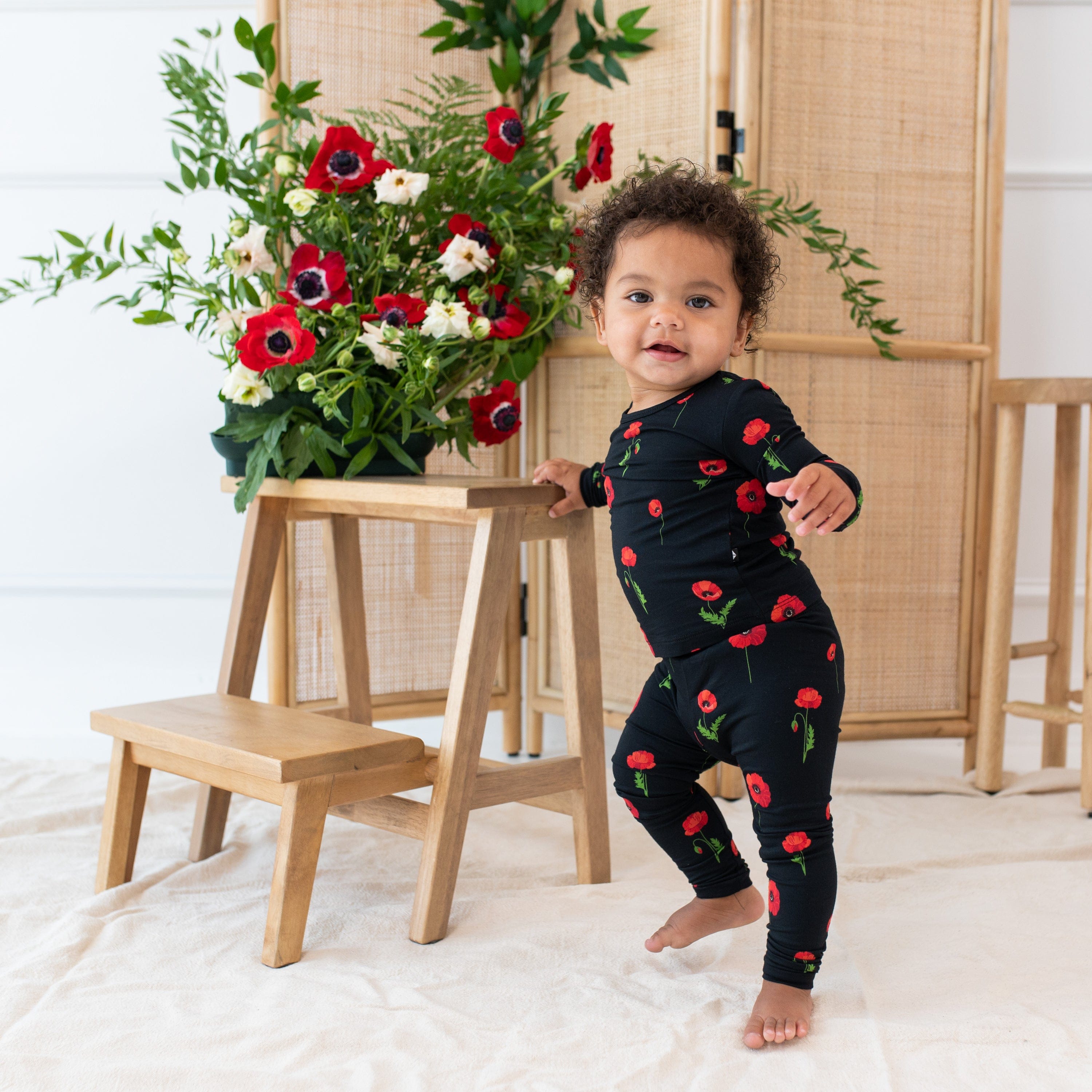 Toddler wearing two piece Kyte Baby Long Sleeve Pajamas in Midnight Poppies