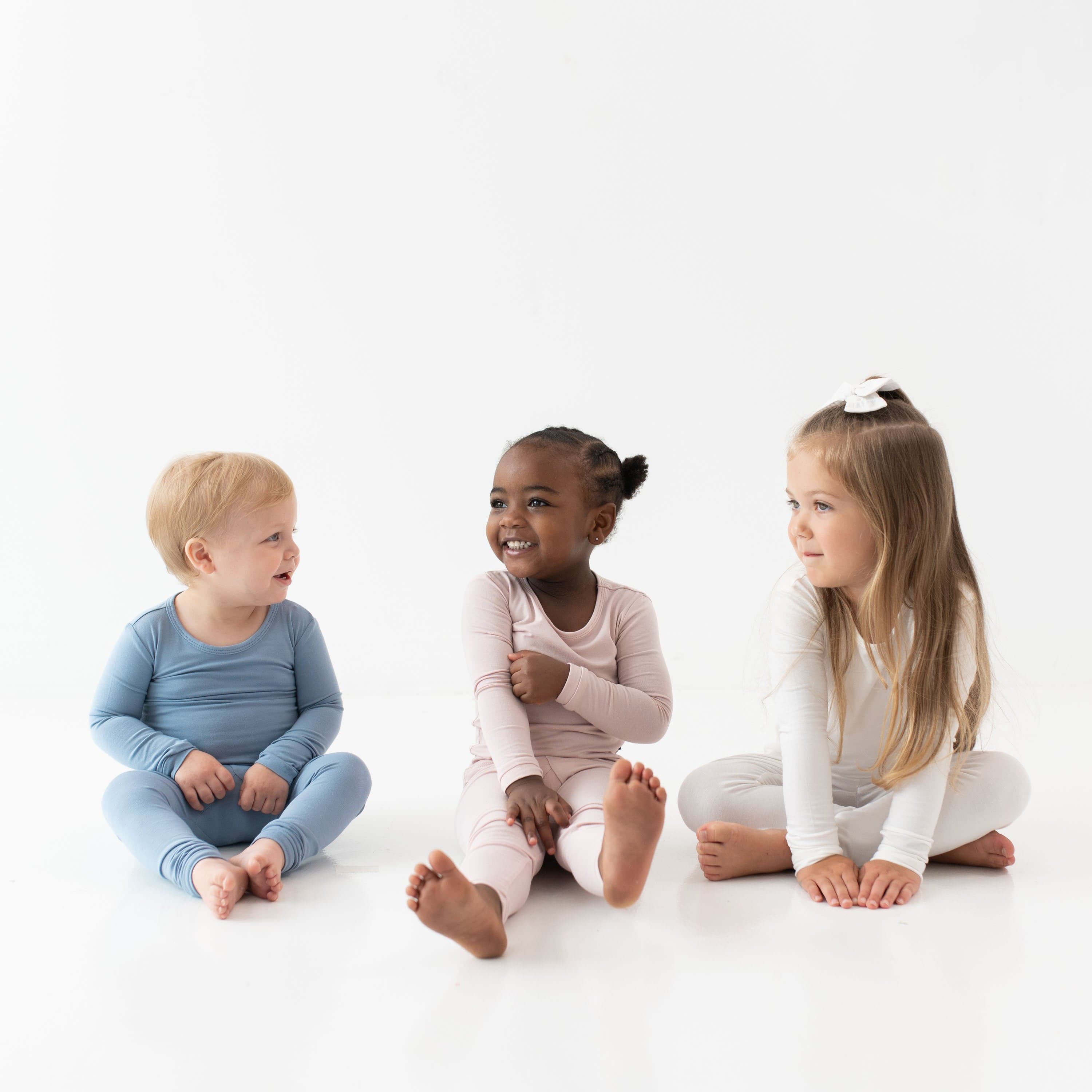 Toddlers sitting next to each other while wearing Long Sleeve Pajamas in Slate, Blush and Cloud