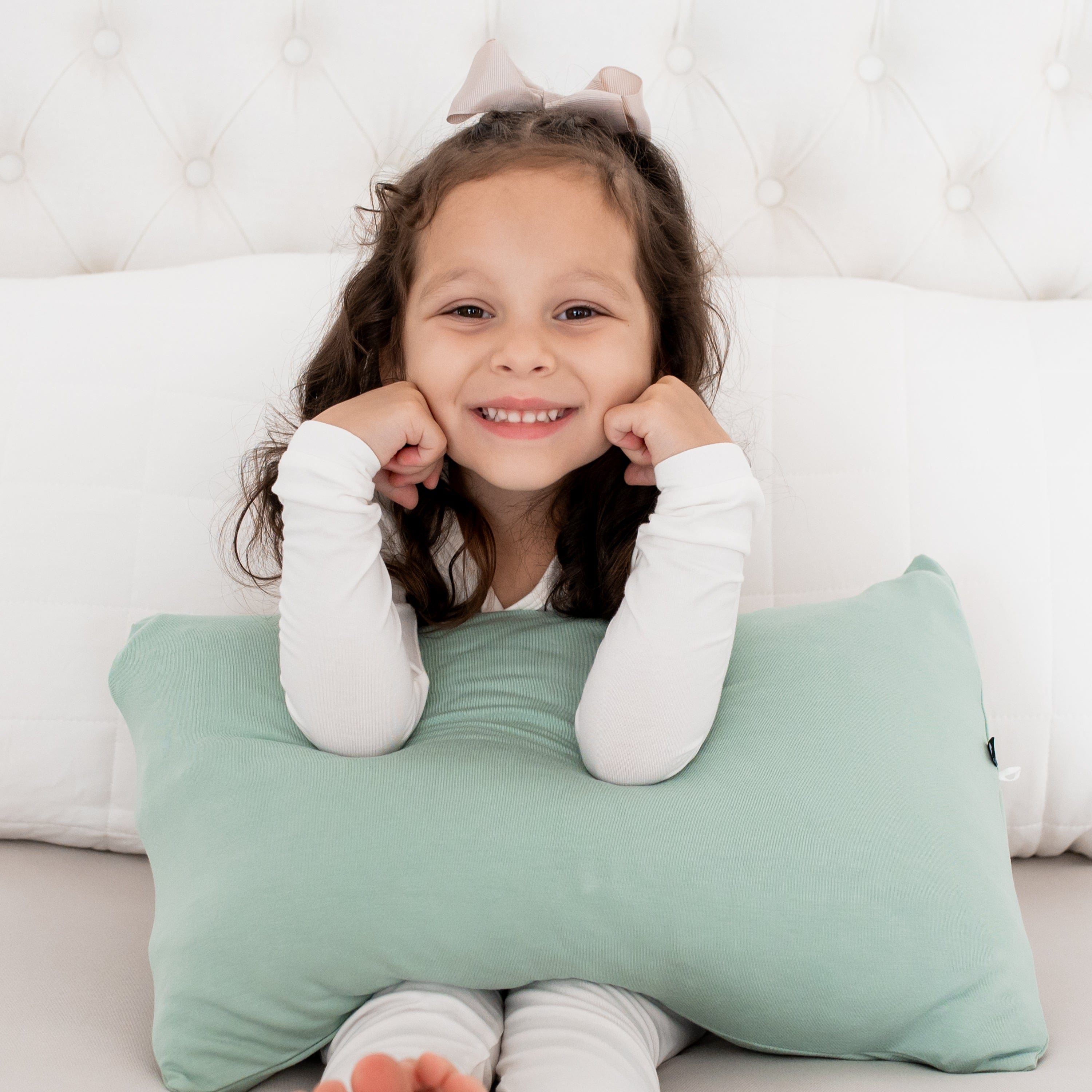 Girl holding Kyte Baby Toddler Pillowcase in Sage
