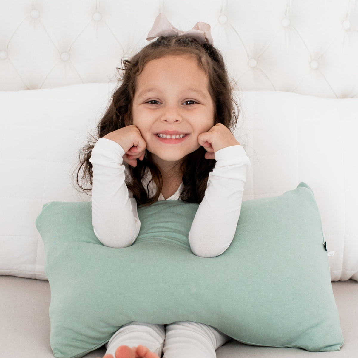 Girl holding Kyte Baby Toddler Pillowcase in Sage