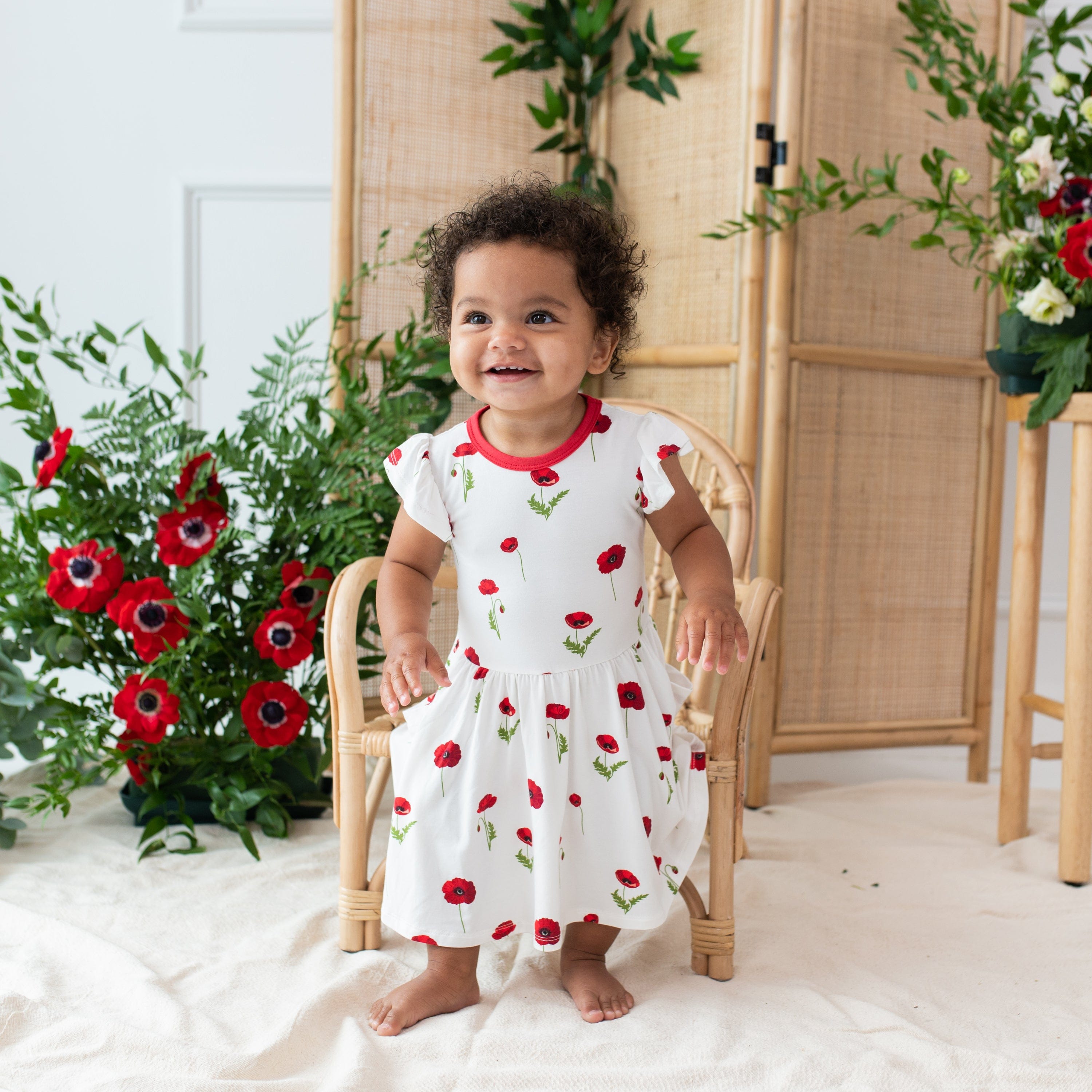 Girl wearing Kyte Baby Pocket Dress in Cloud Poppies