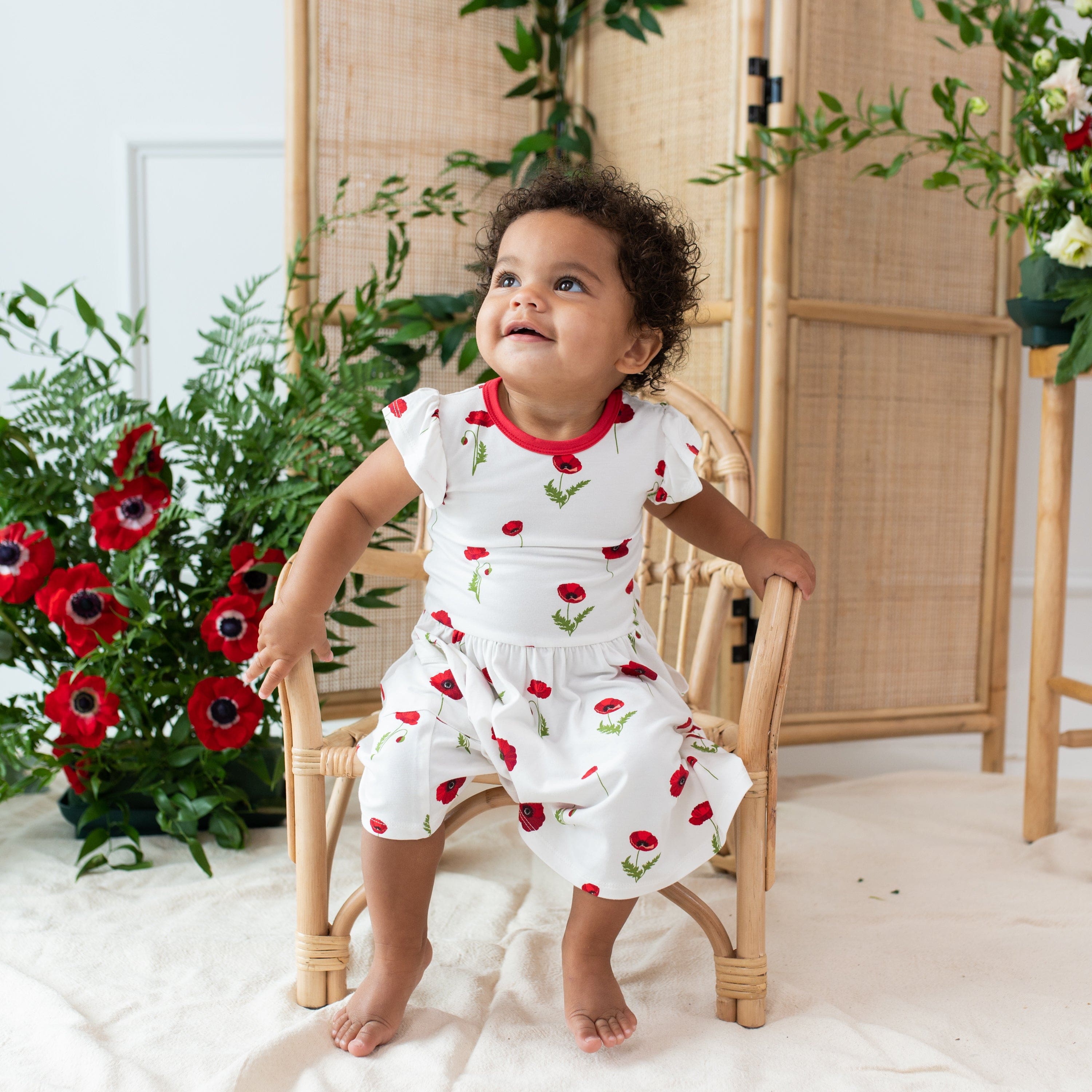 Girl wearing bamboo Kyte Baby Pocket Dress in Cloud Poppies