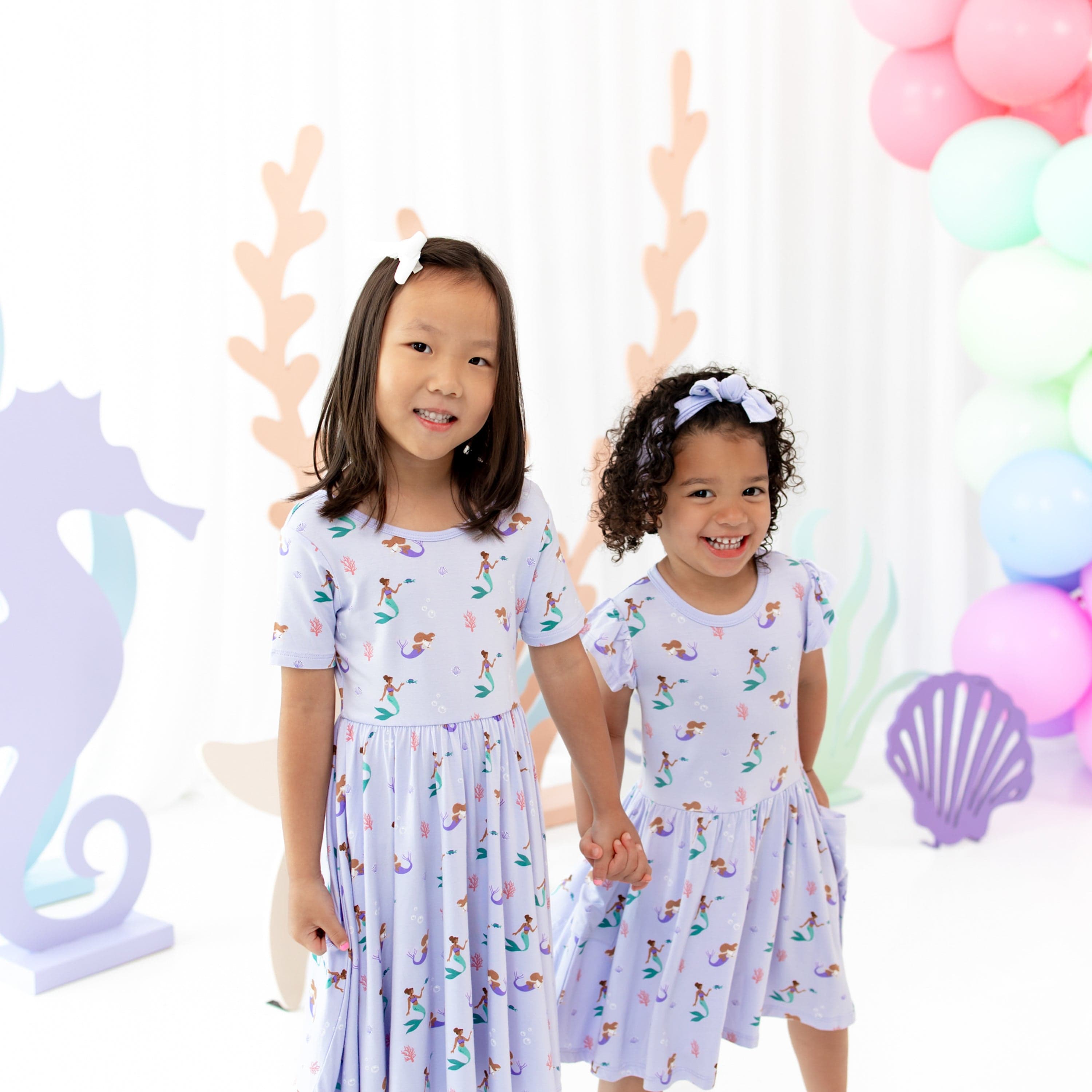 Girls wearing matching Kyte Baby Dresses in Mermaid