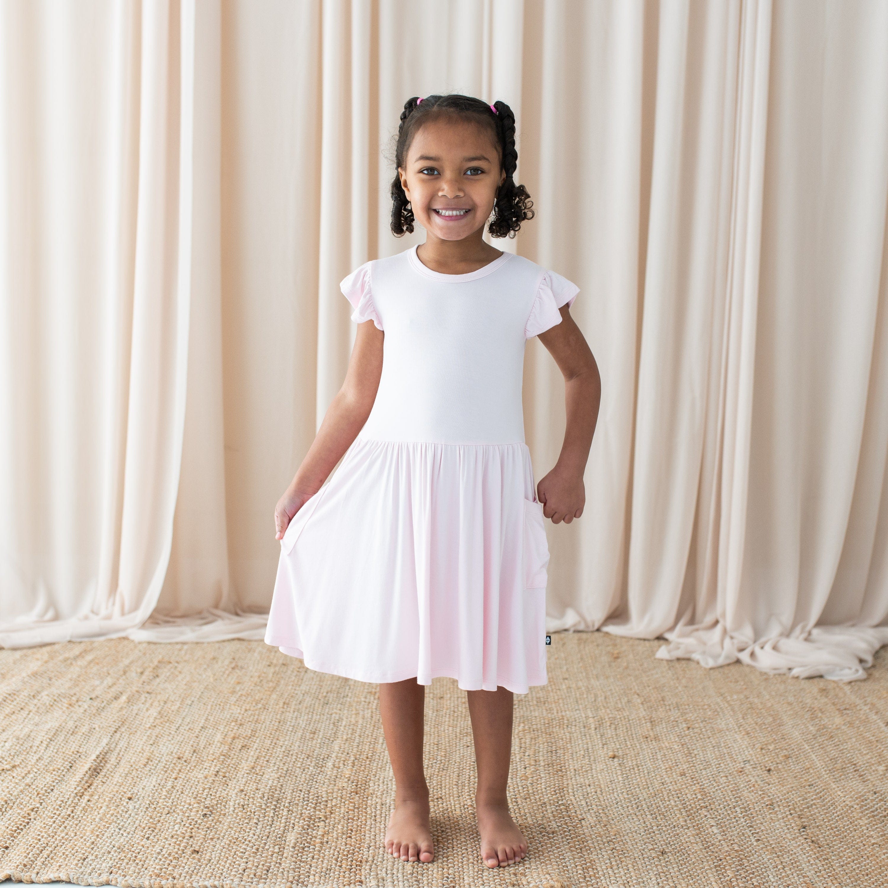 Girl wearing Kyte Baby Pocket Dress in Sakura