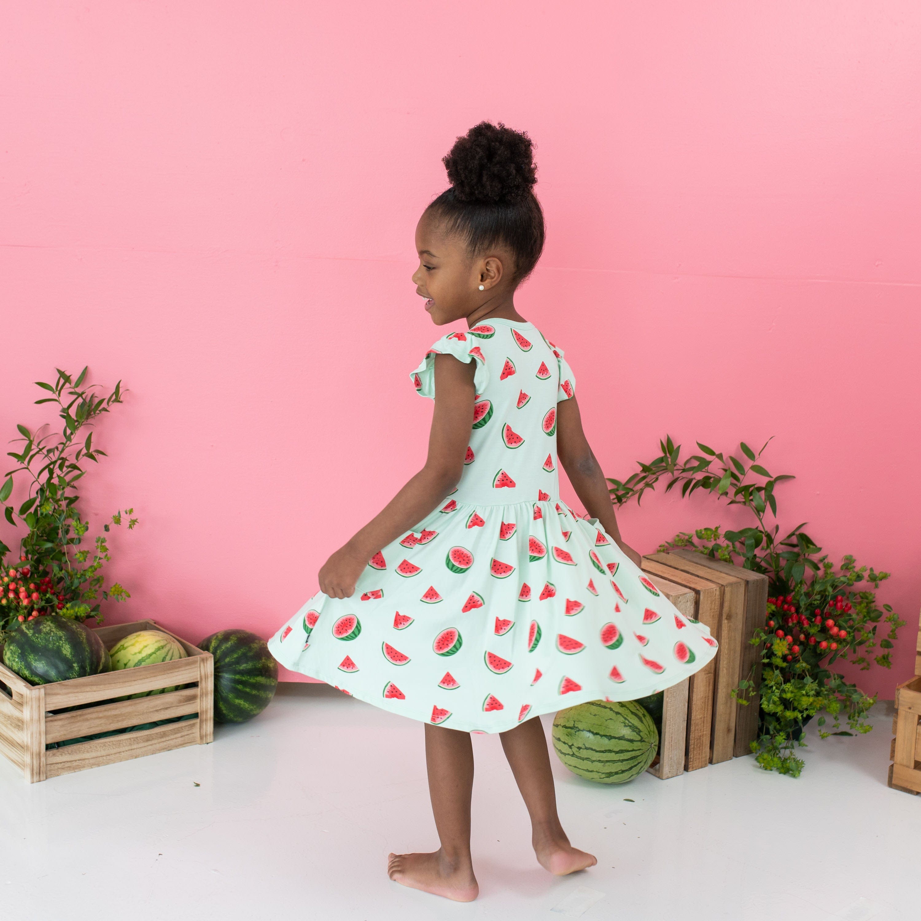 Toddler twirling in Kyte Baby bamboo Pocket Dress in Watermelon