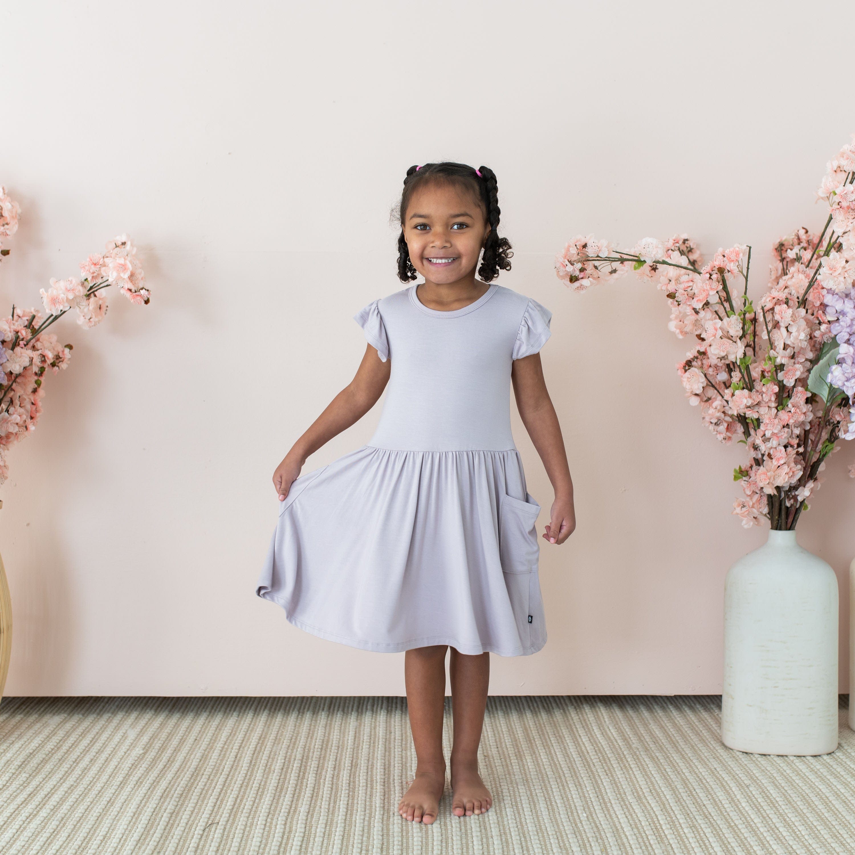 Girl wearing Kyte Baby Pocket Dress in Wisteria